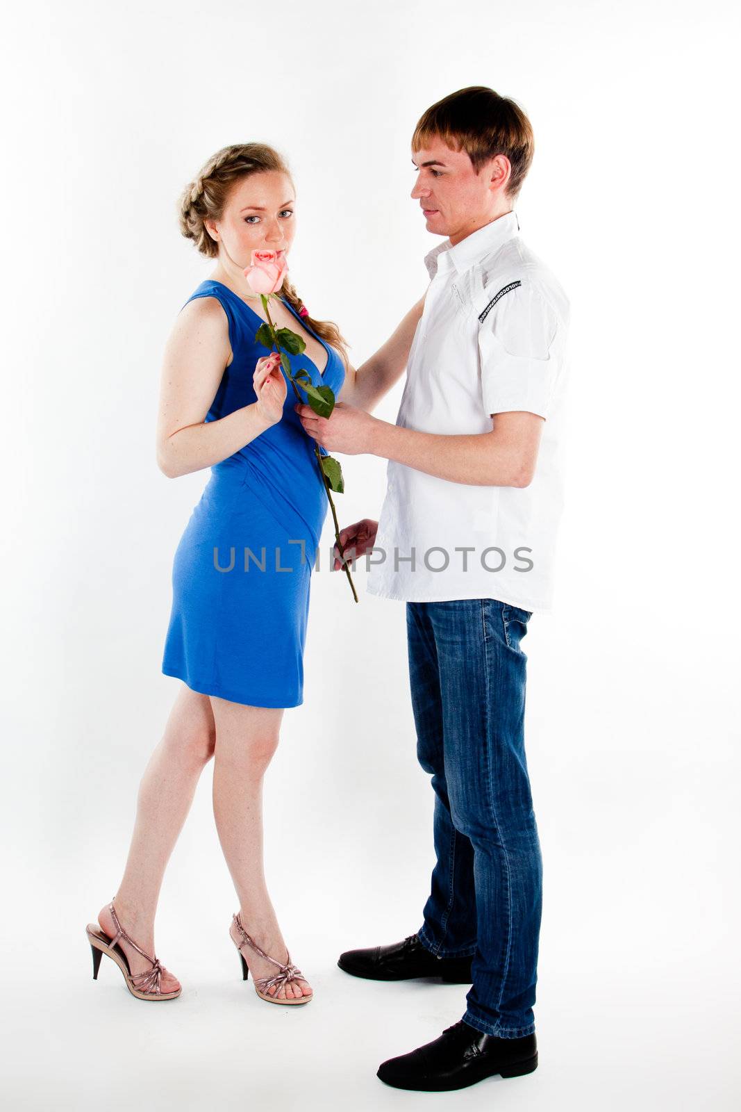A young man gives a beautiful young woman, a flower in honor of the holiday