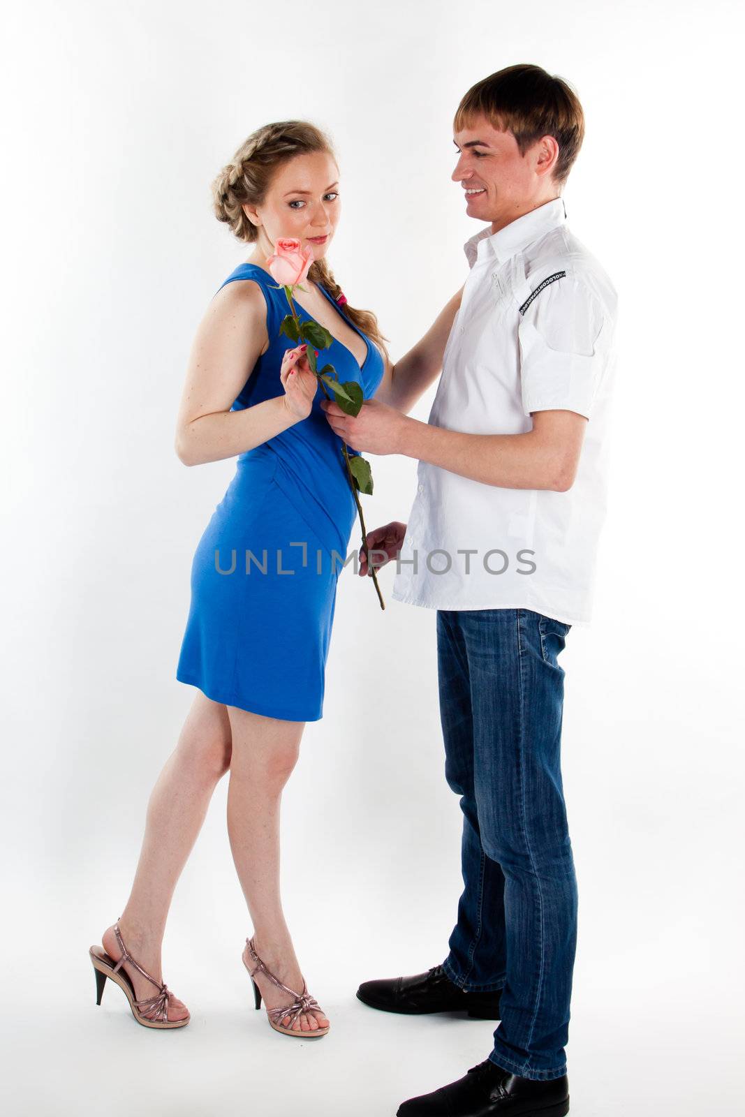 A young man gives a beautiful young woman, a flower in honor of the holiday