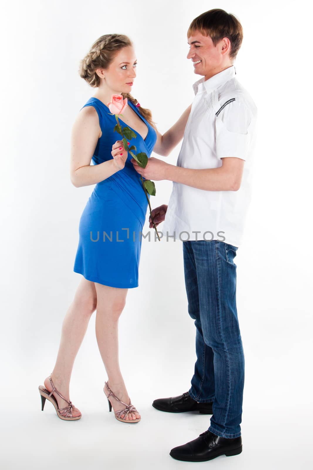 A young man gives a beautiful young woman, a flower in honor of the holiday