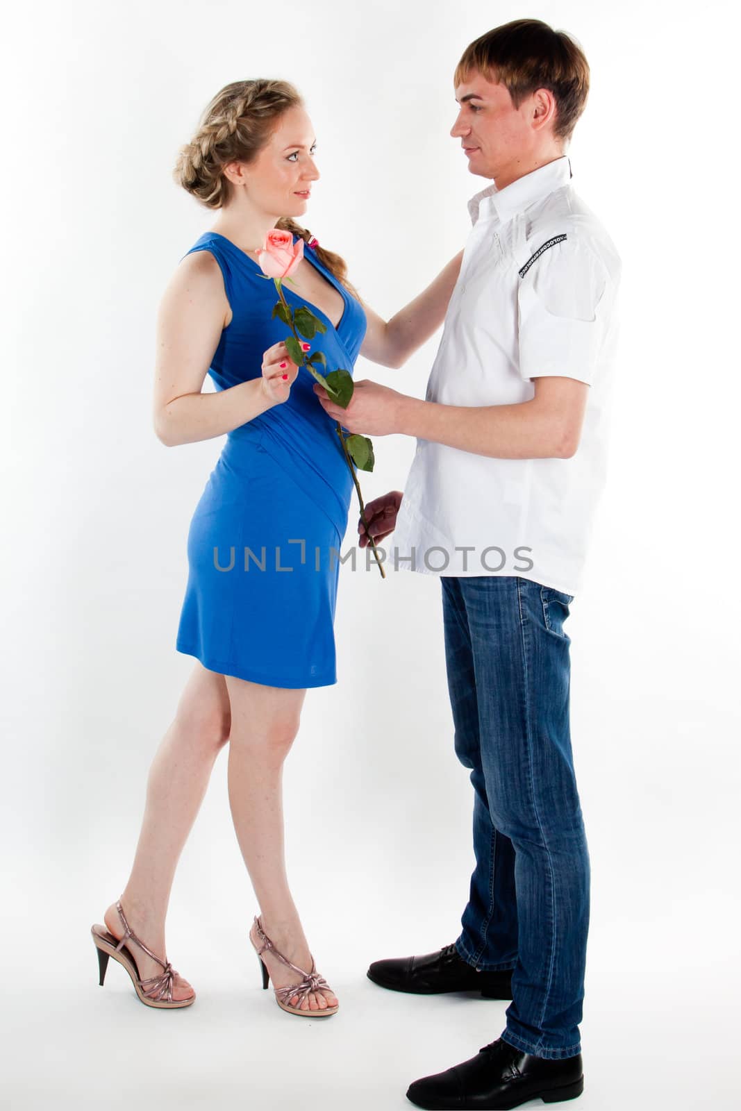 A young man gives a beautiful young woman, a flower in honor of the holiday