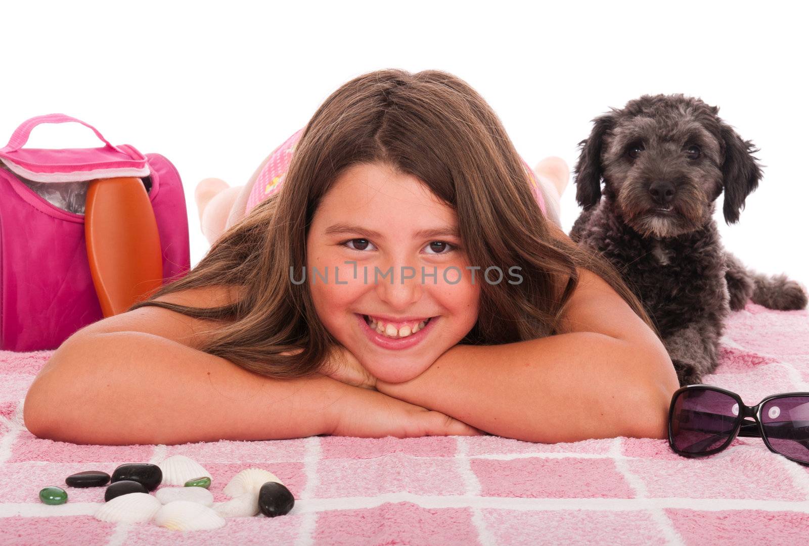 smiling brunette teenage girl in swimsuit at the beach with her shipoo dog (studio setting with beach and personal items) isolated on white background