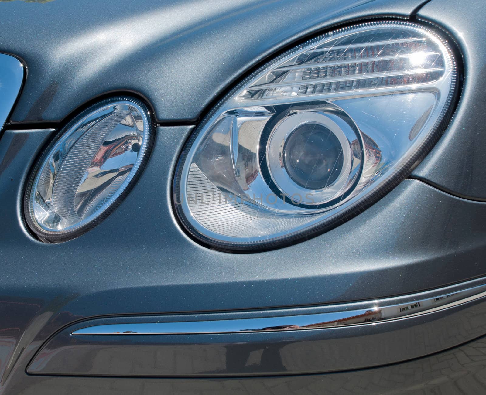 circular car head lights on a gray metallic sports car