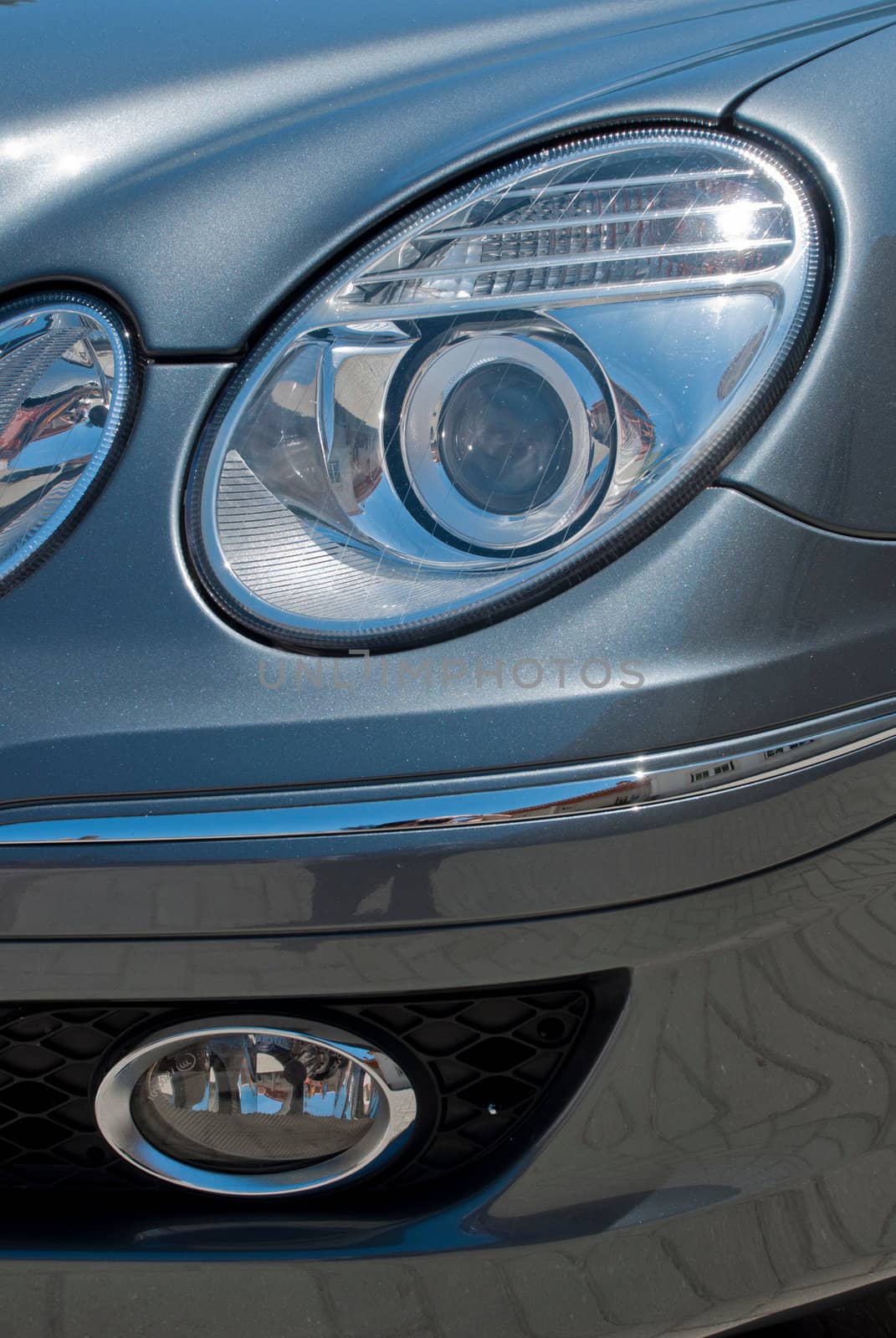 circular car head lights on a gray metallic sports car