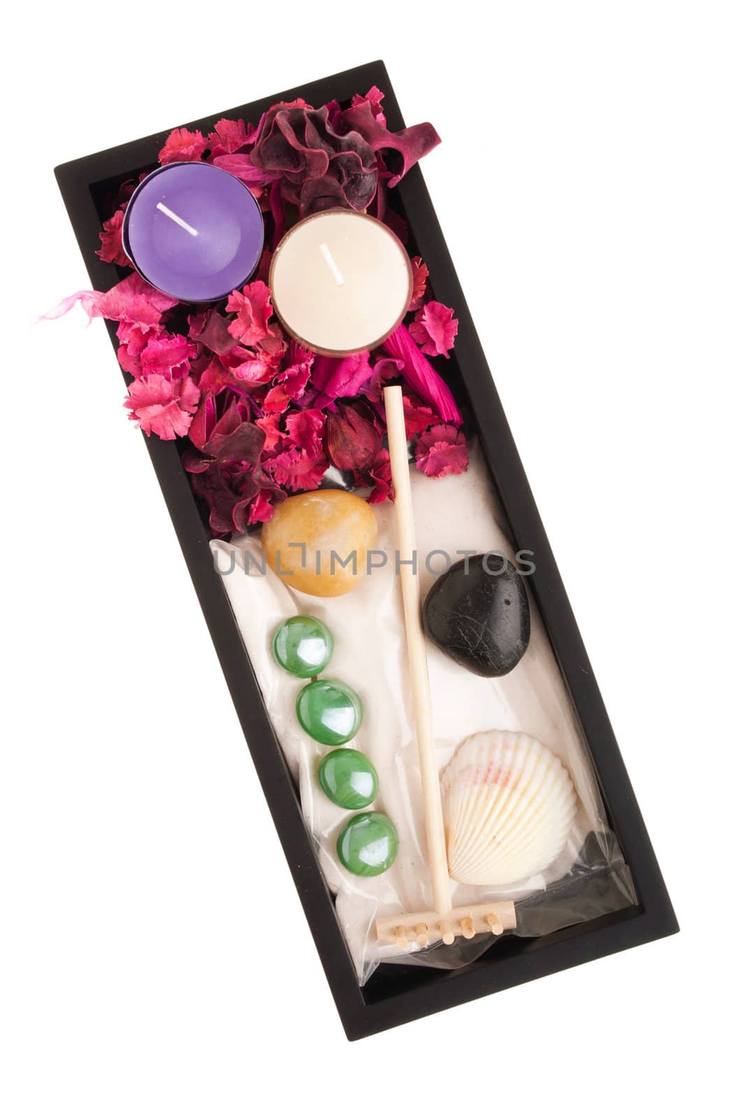 gorgeous spa setting with candles, stones, sand, seashells, rake, dry petal roses and other flowers on a black tray (isolated on white background)