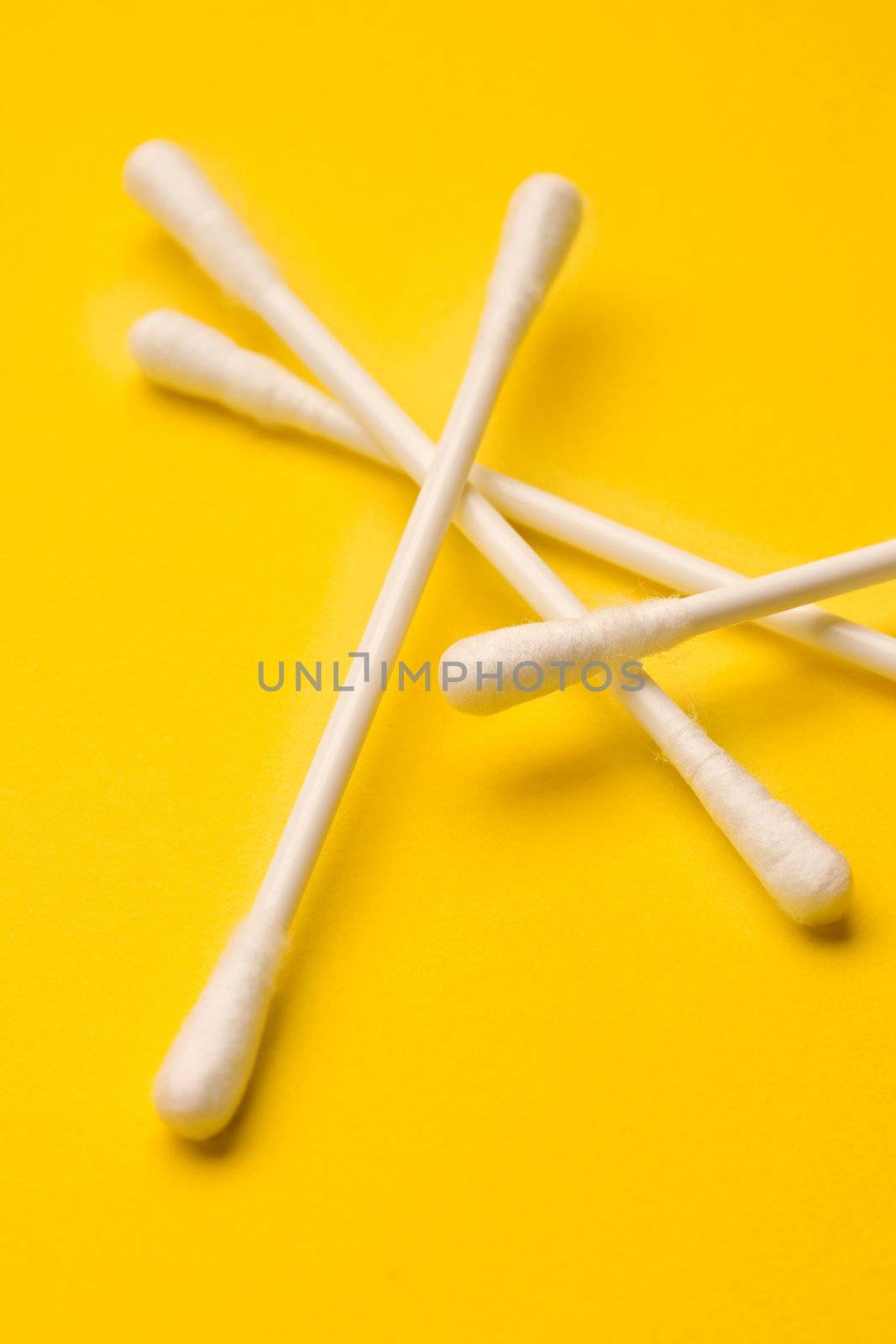 Cotton swabs isolated on yellow background by Garsya