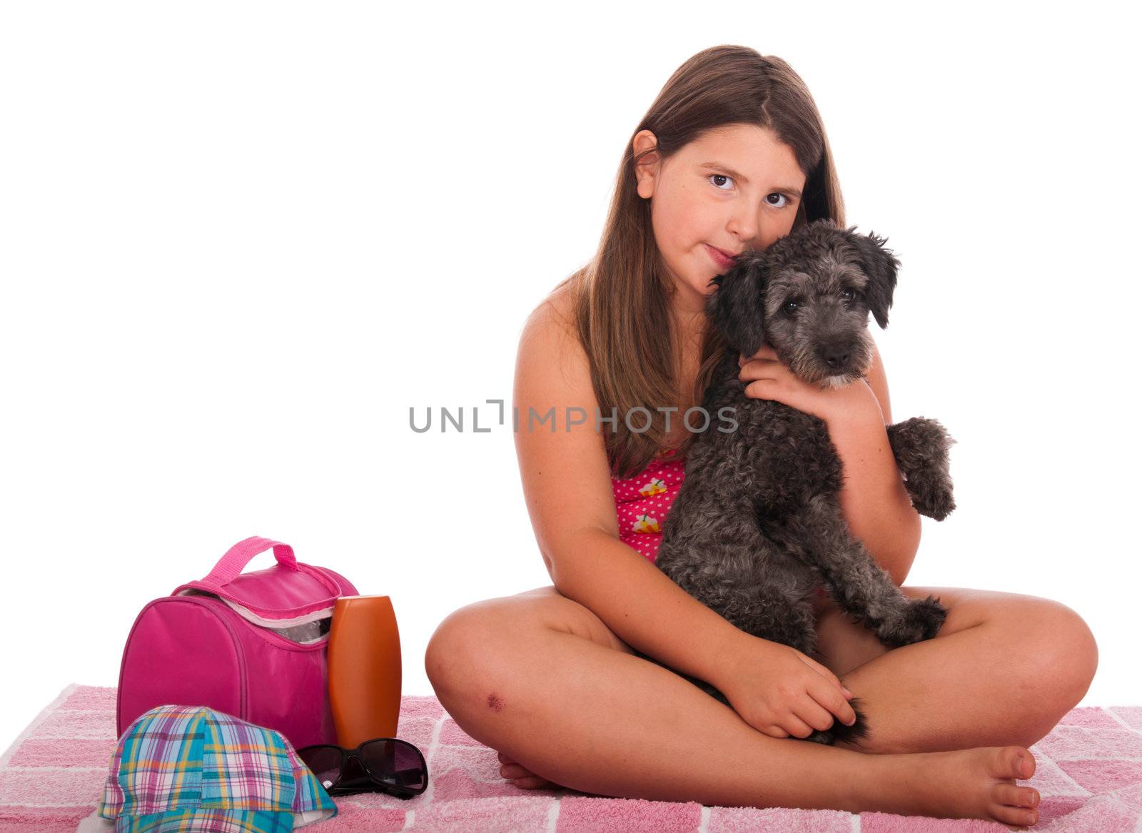 beautiful brunette teenage girl in swimsuit at the beach with her shipoo dog (studio setting with beach and personal items) isolated on white background