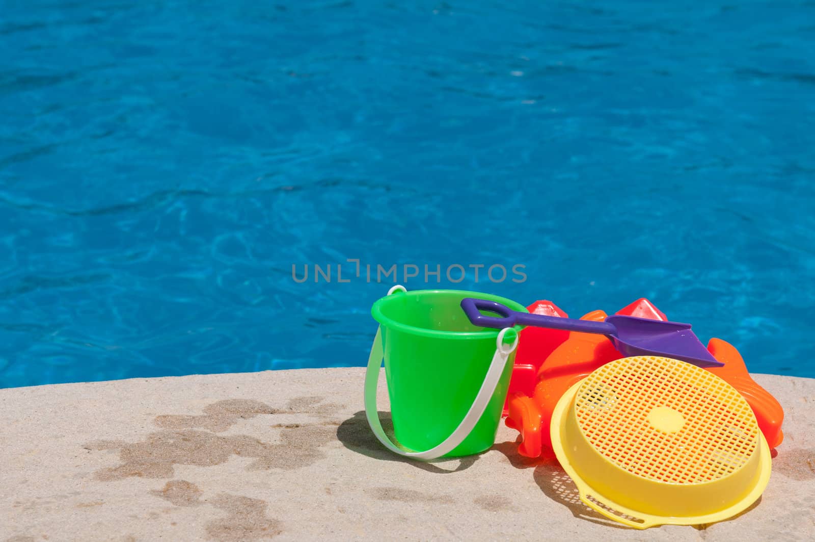 bright and colorful children toys at poolside (family vacations concept)