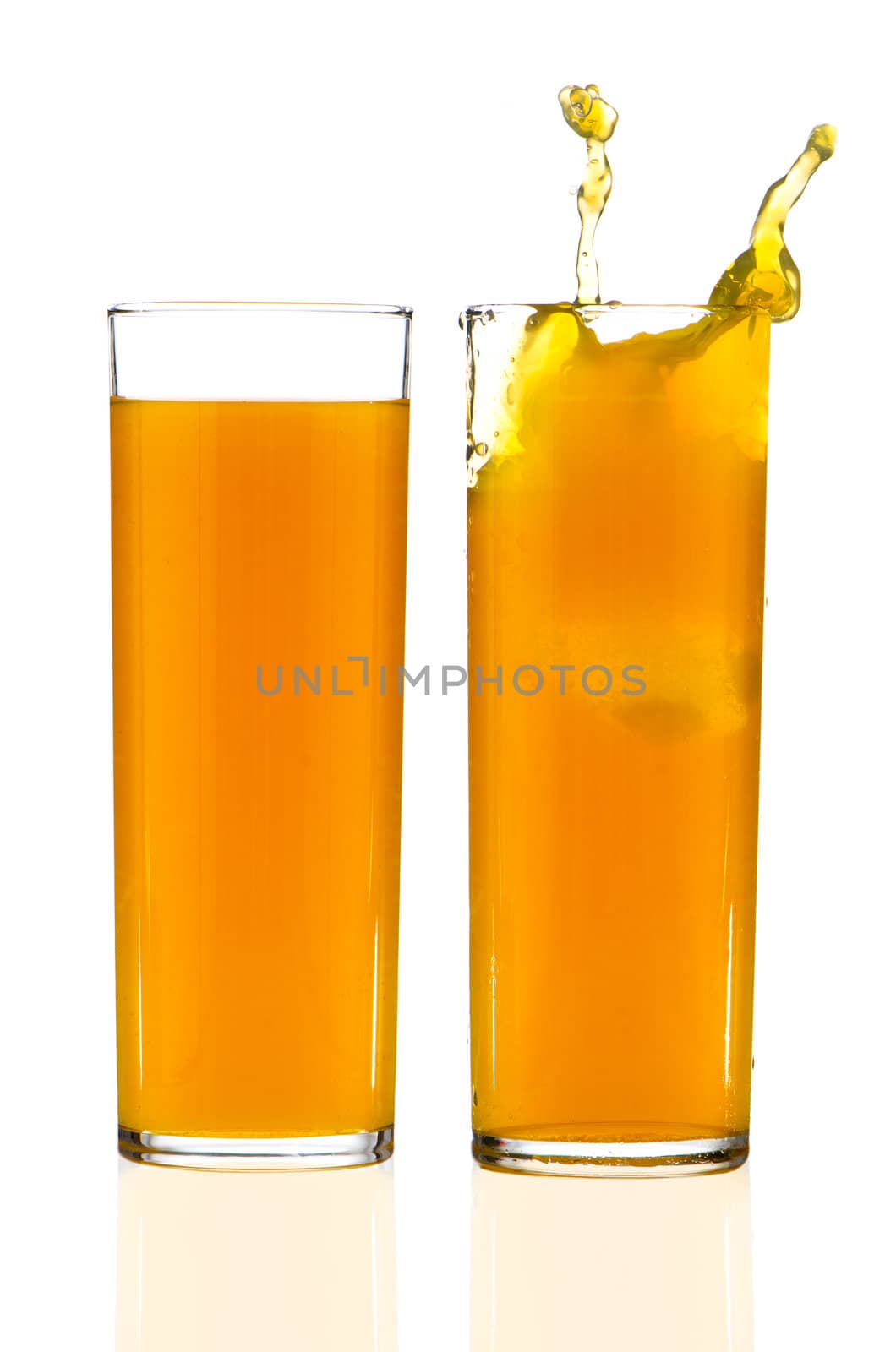 Two cups of orange juice over white reflective background.