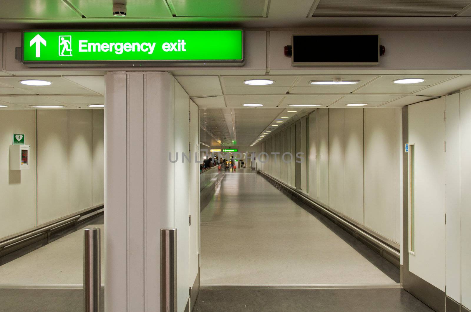 green emergency sign at a international airport corridor