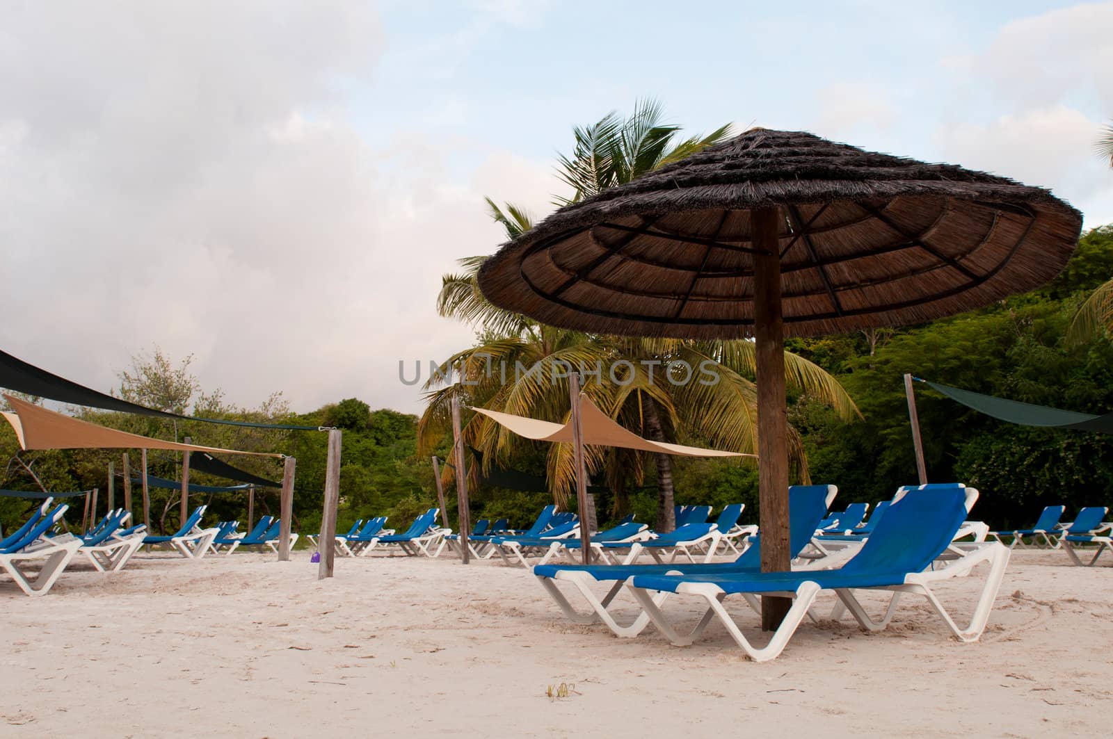 beach chairs and umbrella on a tropical beach resort in Antigua (sunset picture)