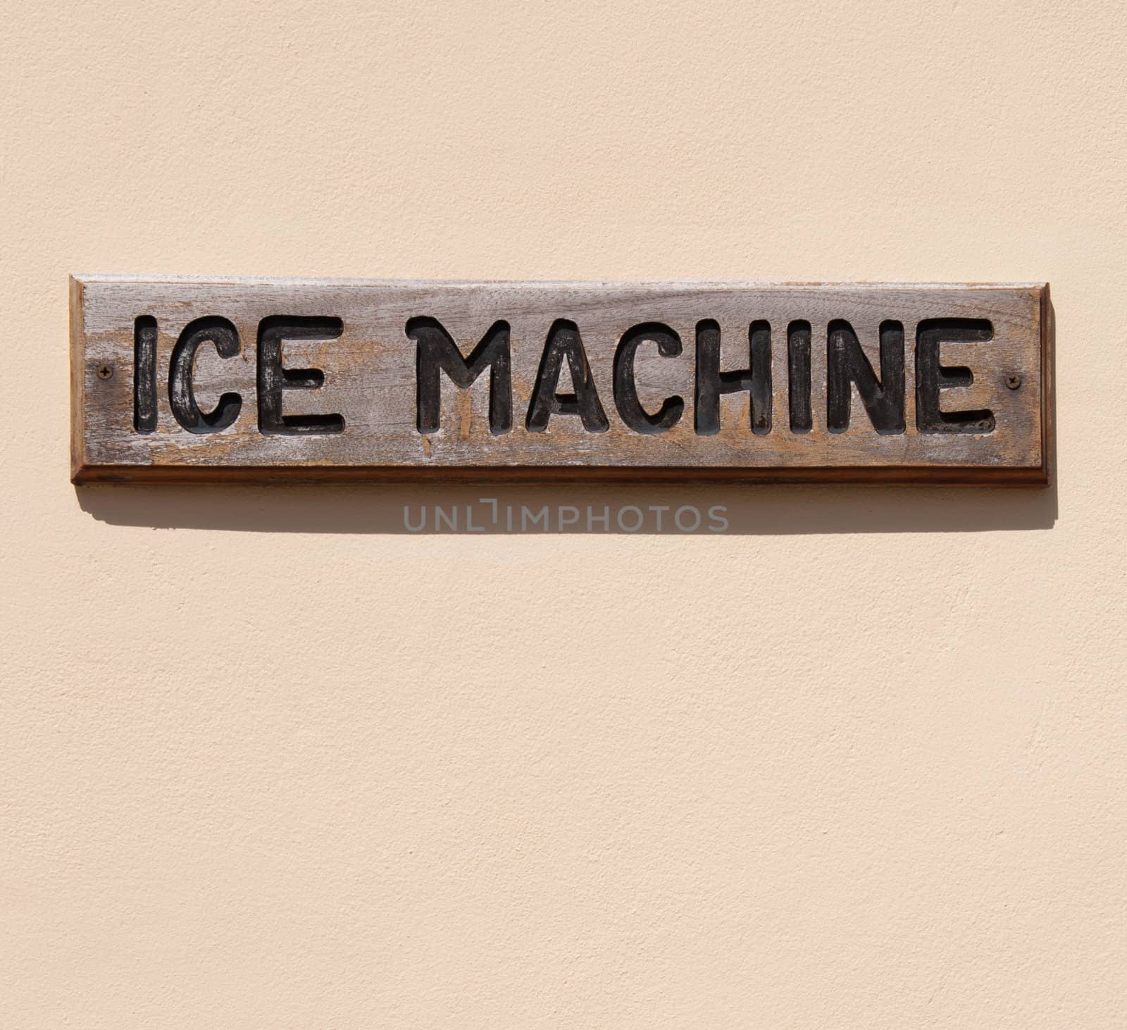 wooden ice machine sign on a pink wall (usual at tropical resorts)