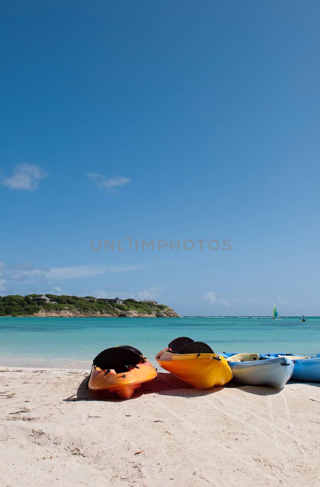 colourful kayaks on a white sandy beach, Long Bay in Antigua (blue sky background)
