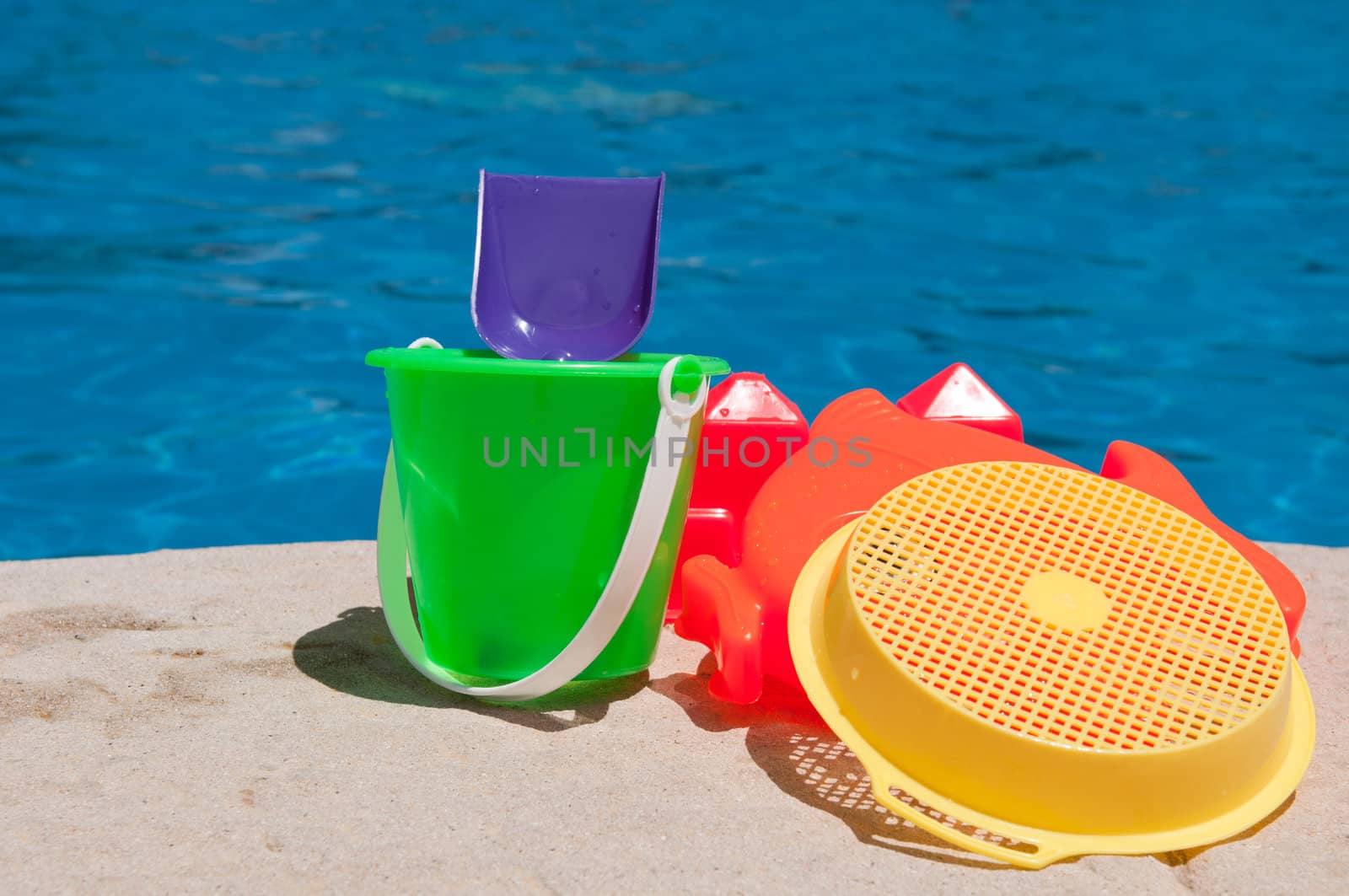 bright and colorful children toys at poolside (family vacations concept)