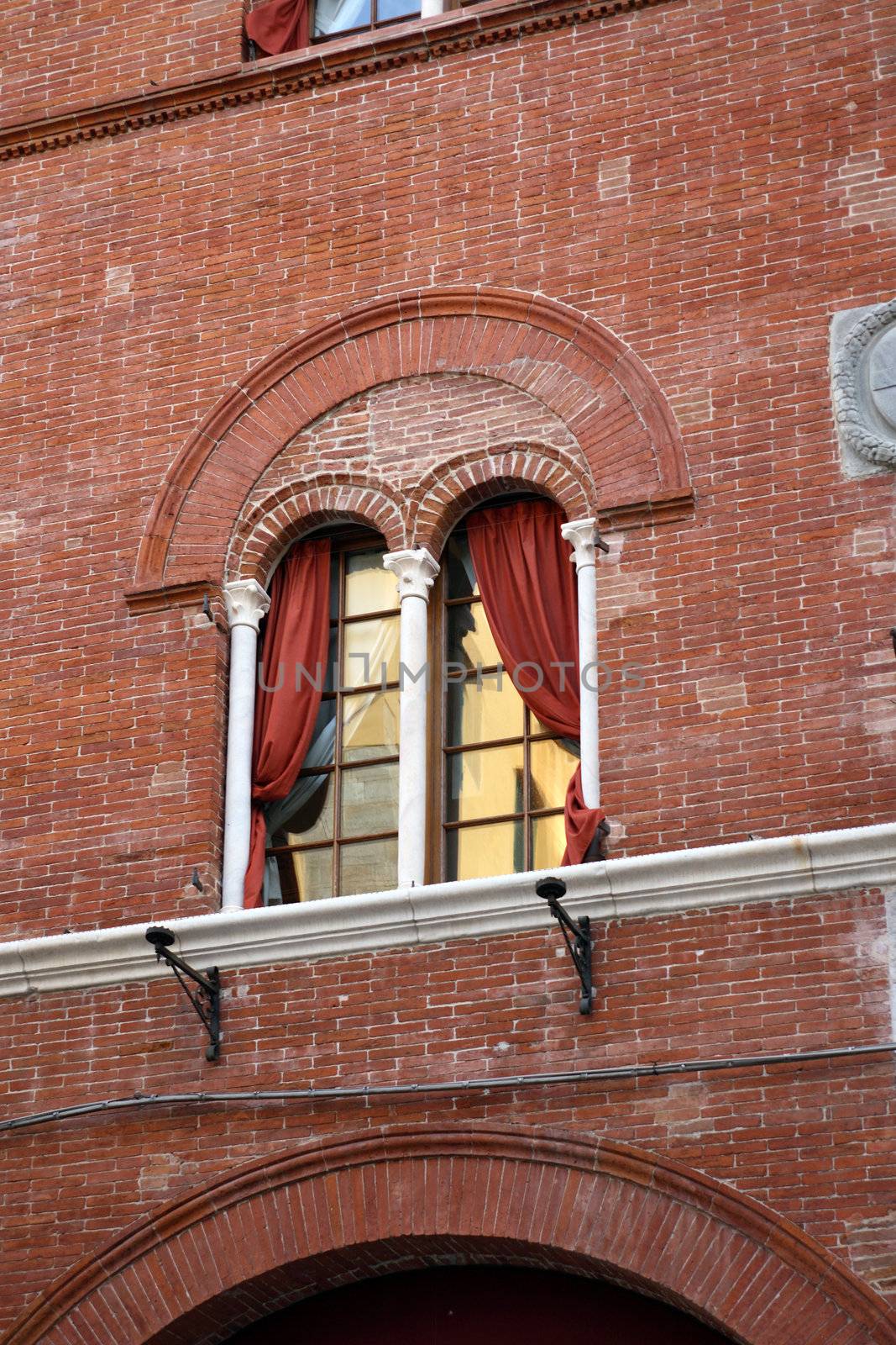 Nice vintage window with red venetian blind on brick wal