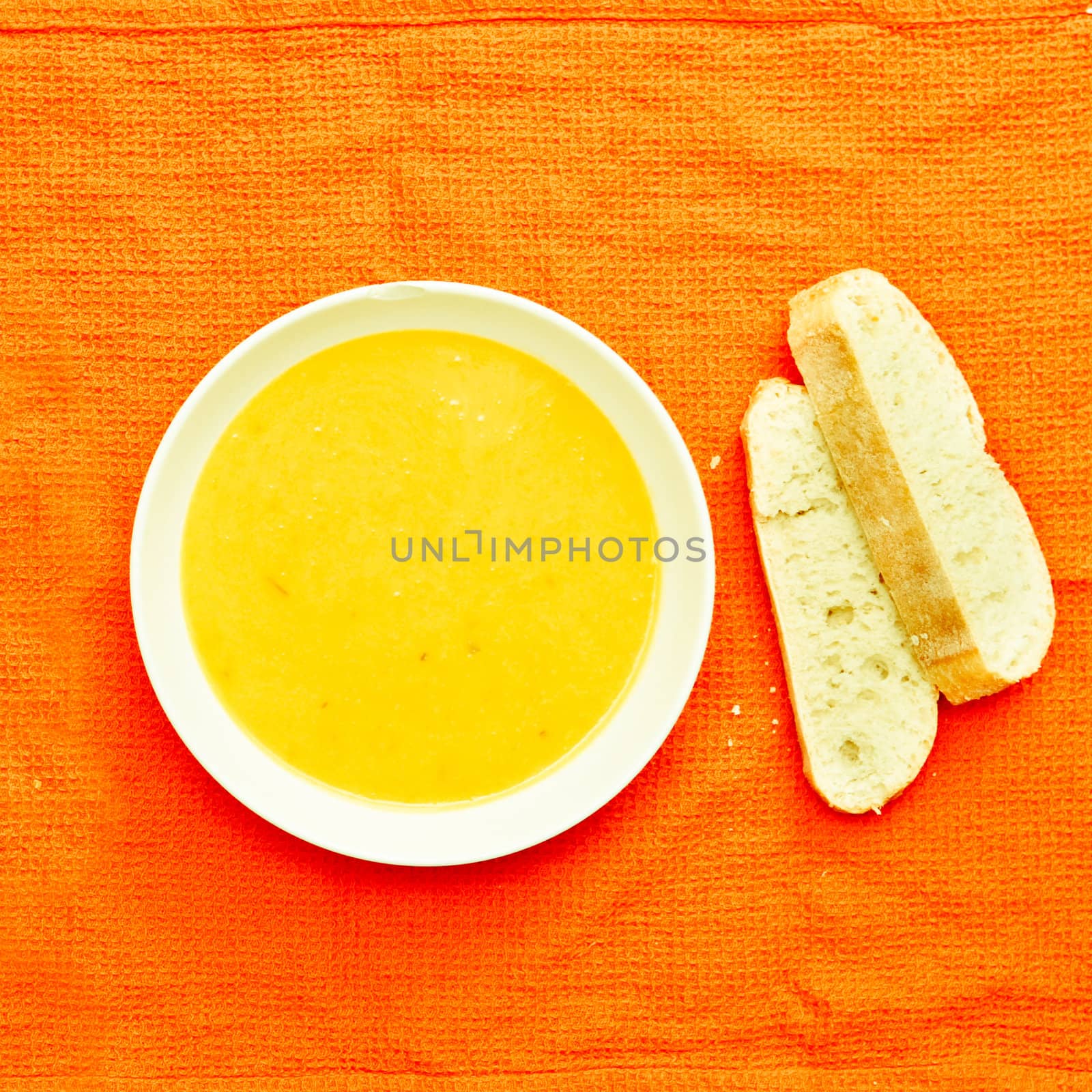 Butternut squash soup and fresh bread on a cloth
