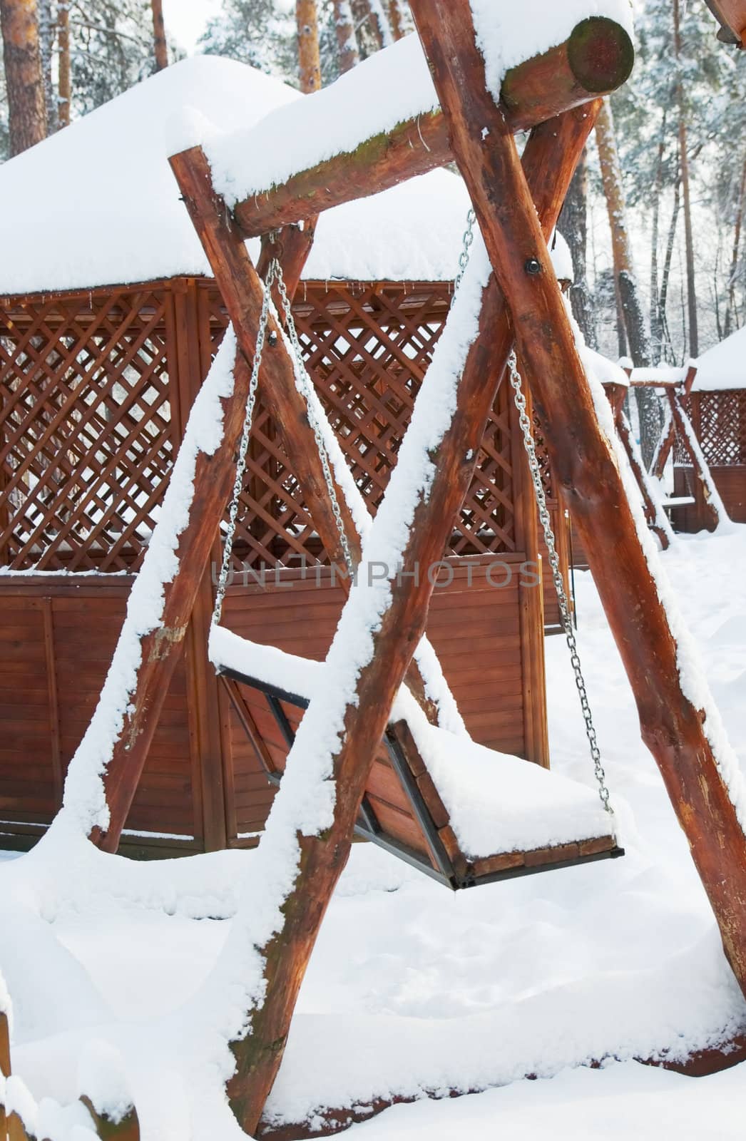 Wooden swing in a park covered with snow