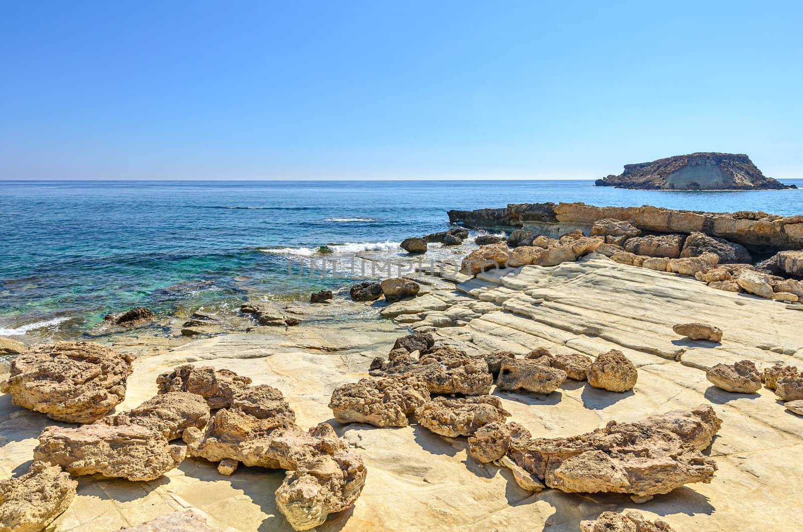 Landscape with rocky coast and island on the horizon