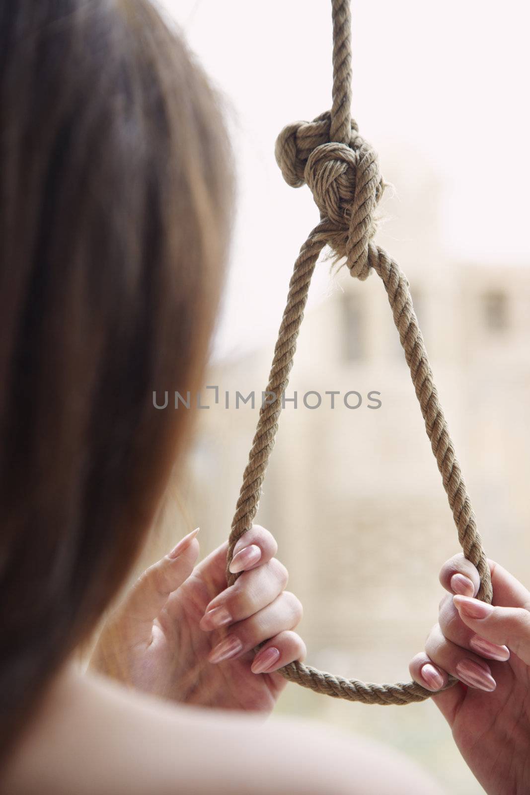 Rear view on the woman holding slipknot as a symbol of suicide