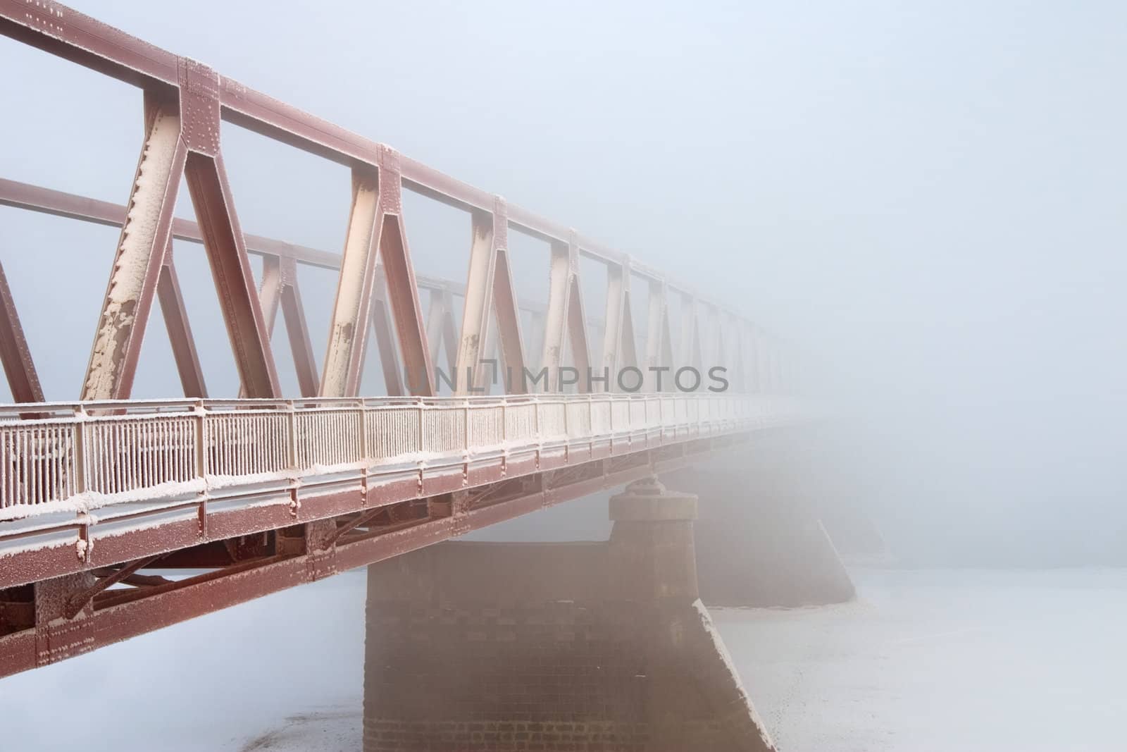 Kind on the bridge through the river in foggy morning