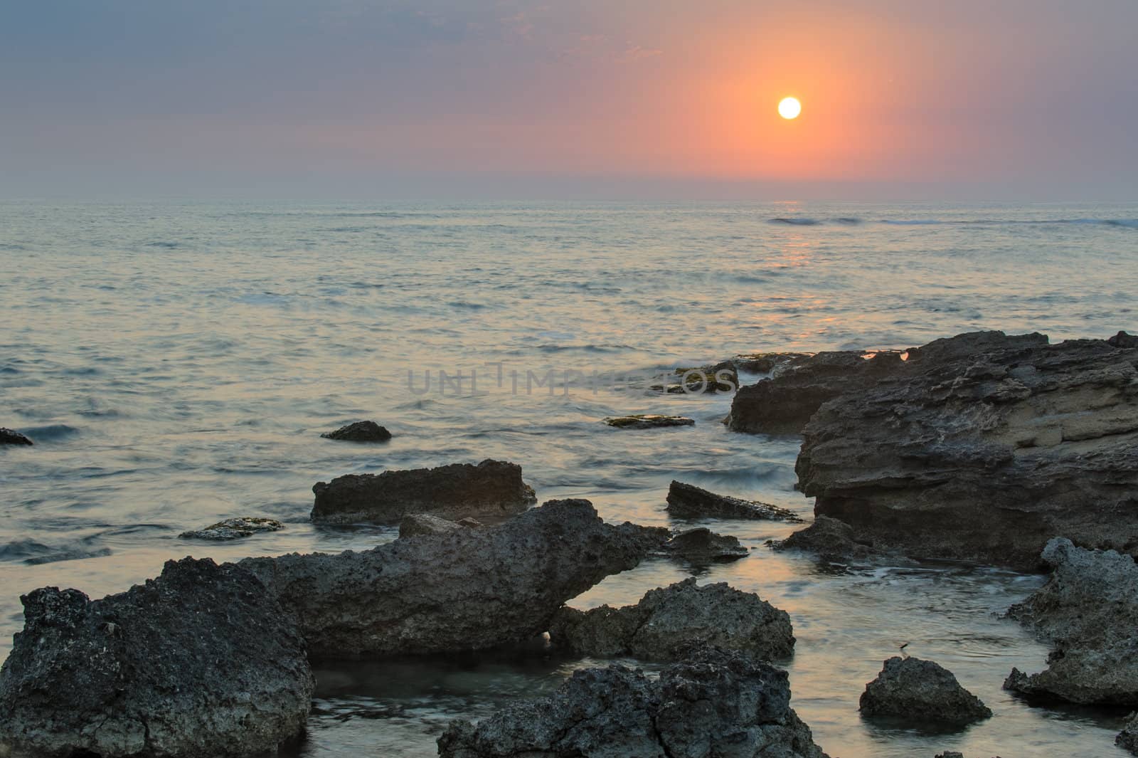 Sunset over the sea and rocky coastline