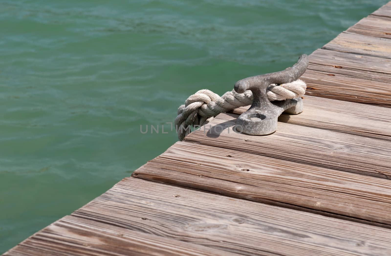 old iron mooring cleat on a wooden pier (green lagoon)