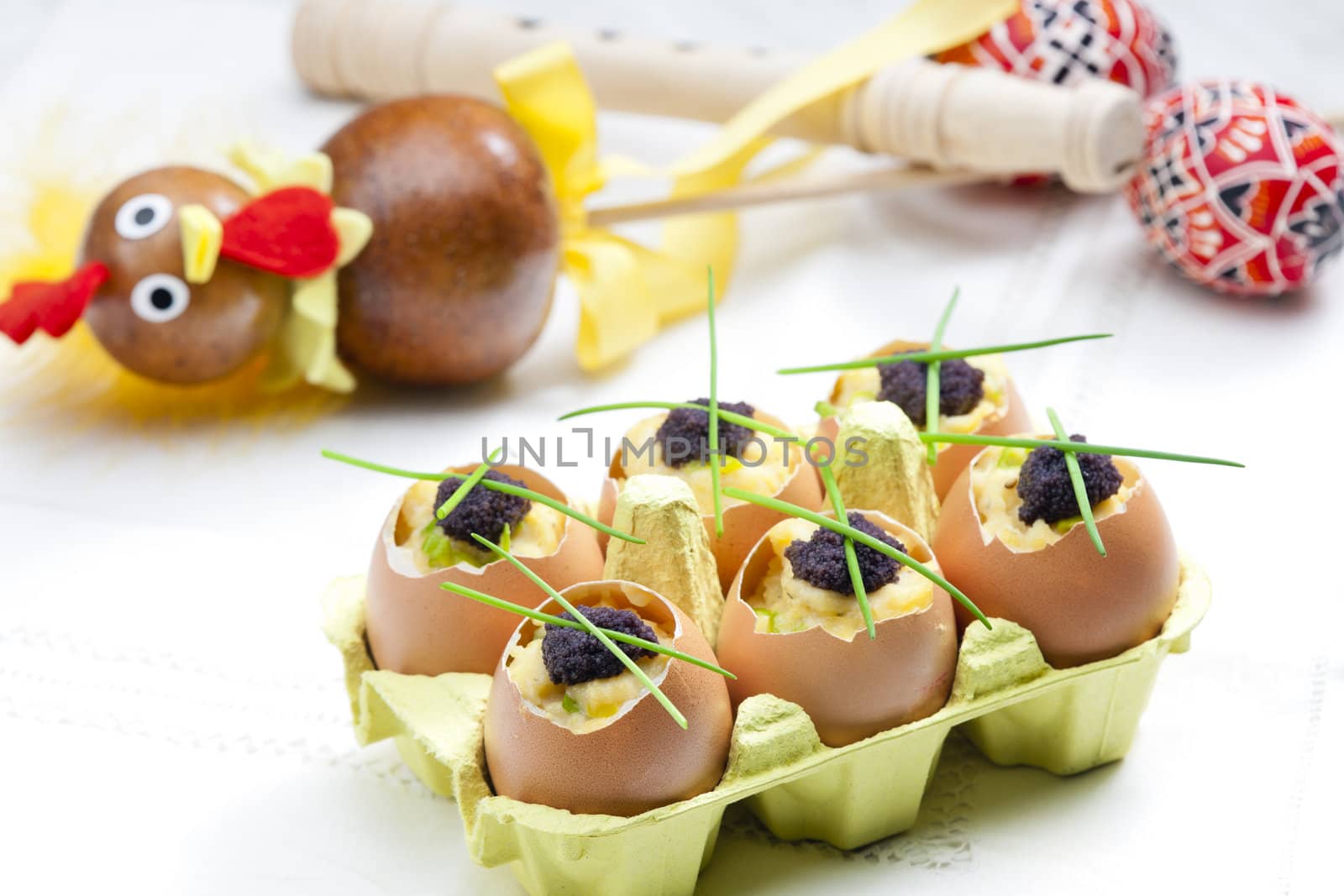 Easter still life with scrambled eggs, chives and black caviar