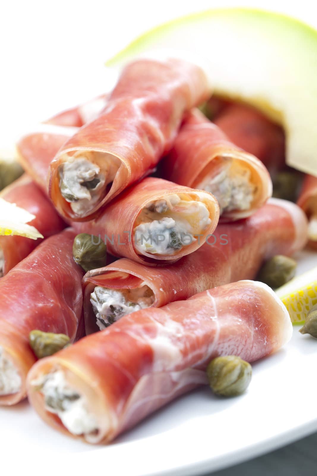 Parma ham rolls filled with cream cheese, Galia melon and capers