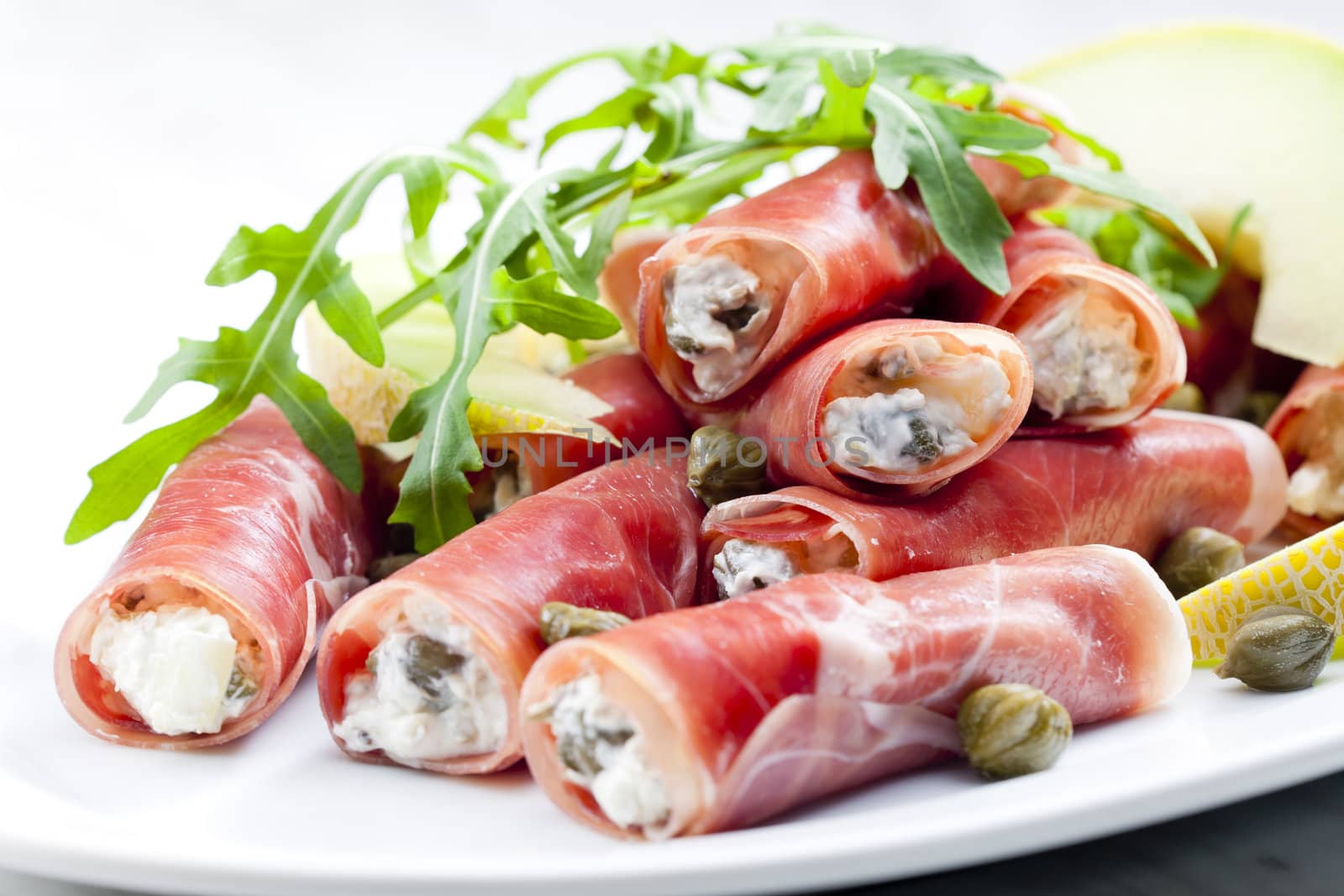 Parma ham rolls filled with cream cheese, Galia melon and capers