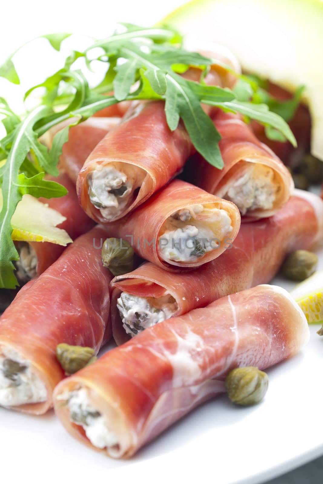 Parma ham rolls filled with cream cheese, Galia melon and capers
