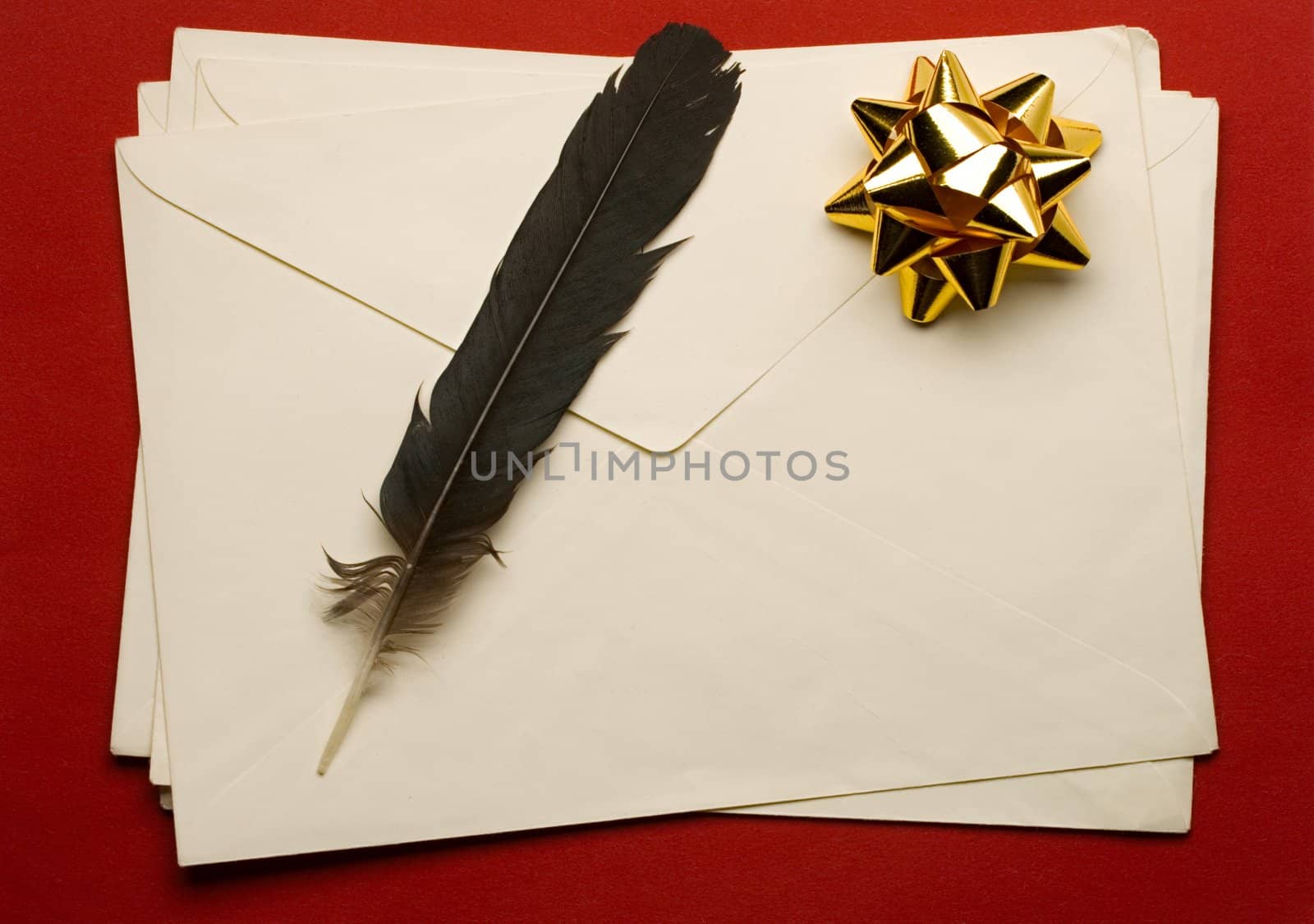 Envelope with ribbon and feather isolated on red background by Garsya