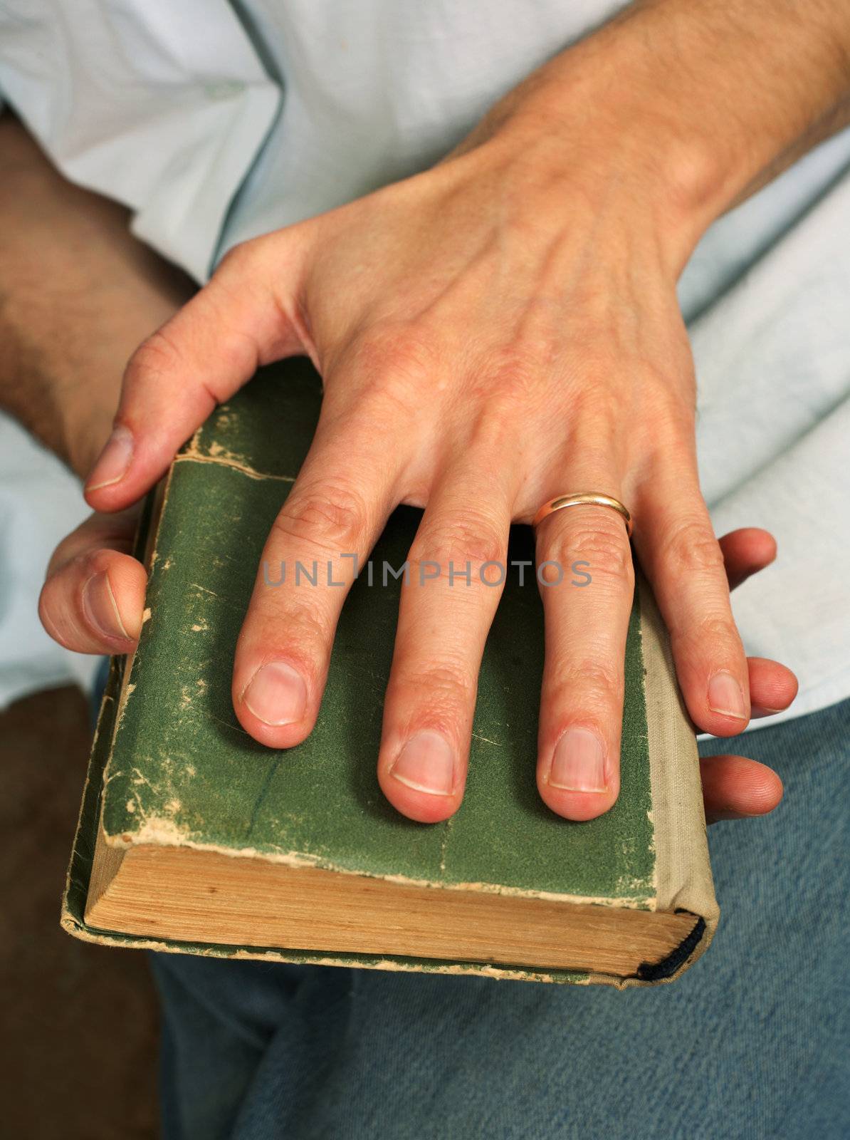 Man's hands hold the old green book