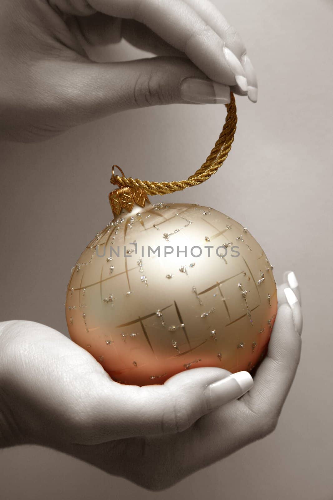 Gold sphere in female hands. Partial decolouration