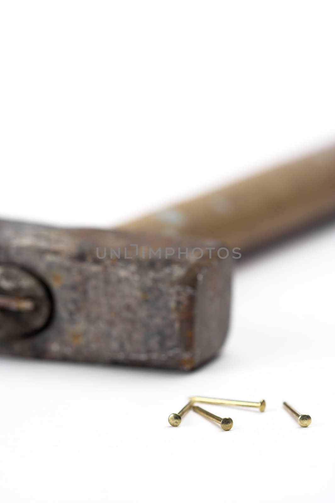 Hammer and golden nails isolated on white