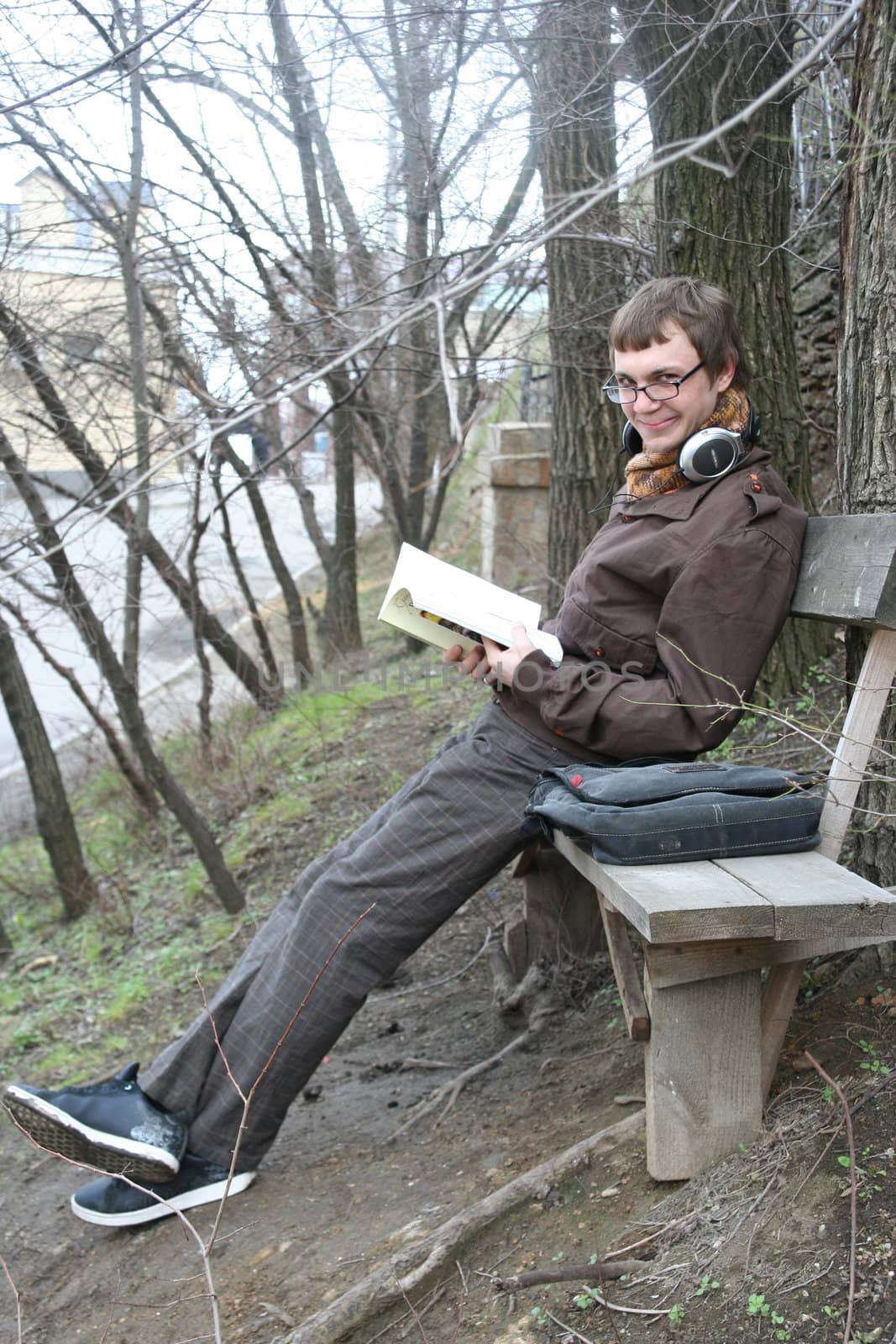 The guy sits on a shop and reads the book
