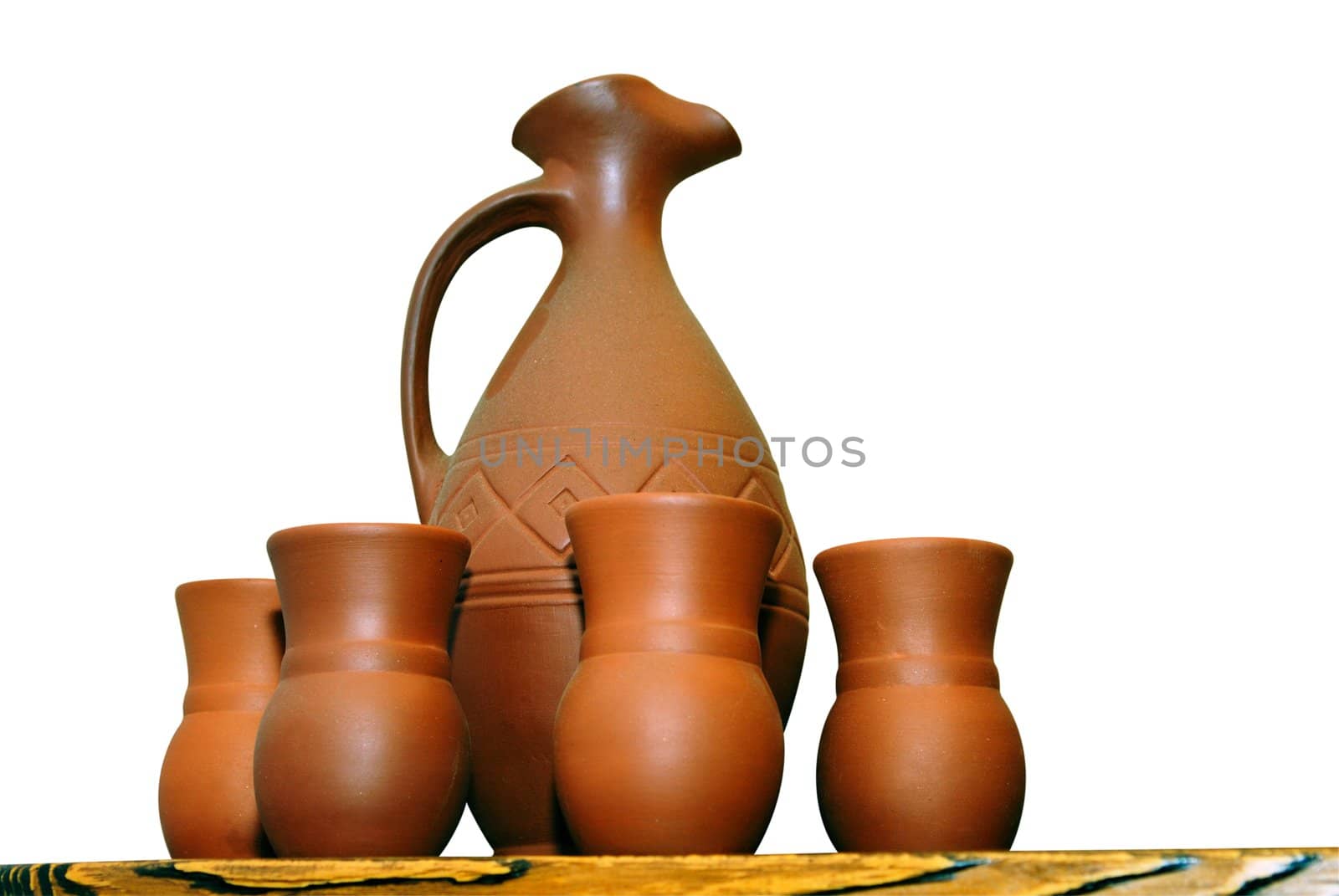 Clay jugs and cups on a shelf isolated on white