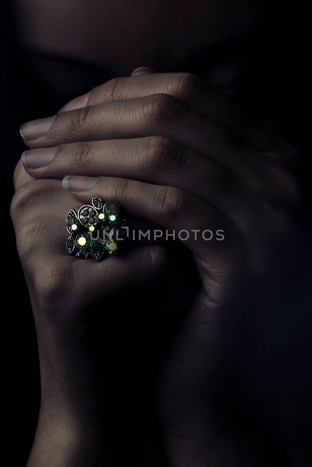 Studio portrait of model's hands with jewel ring in dramatic light