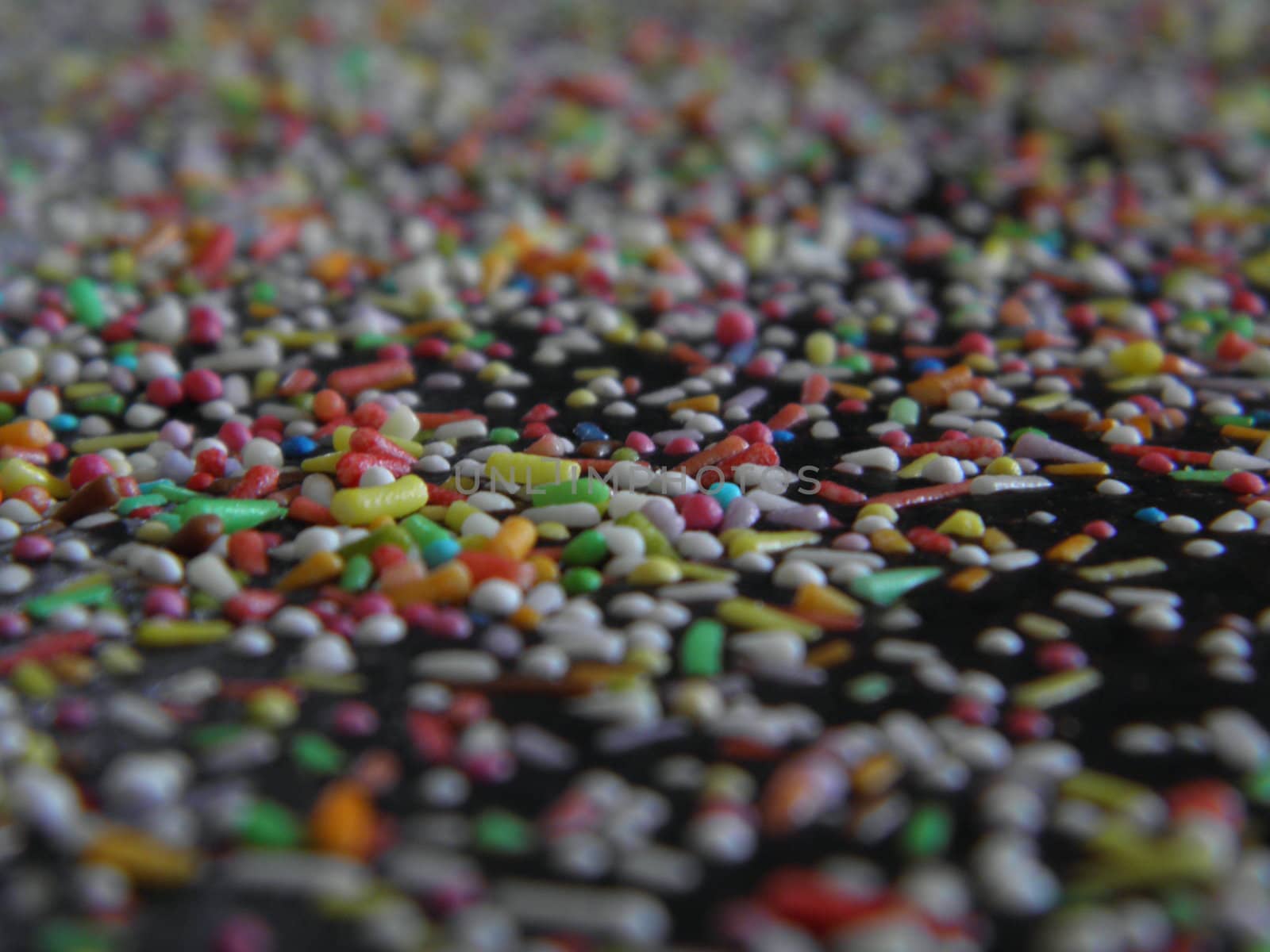 Close up of colorful candy sprinkles on top of a cake.