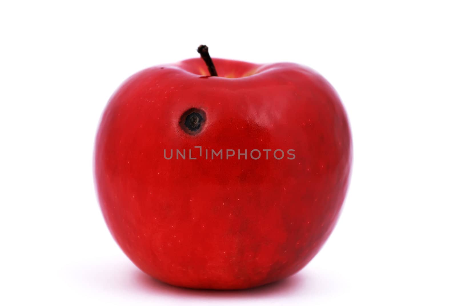 red apple with a ruffled hole on a white background