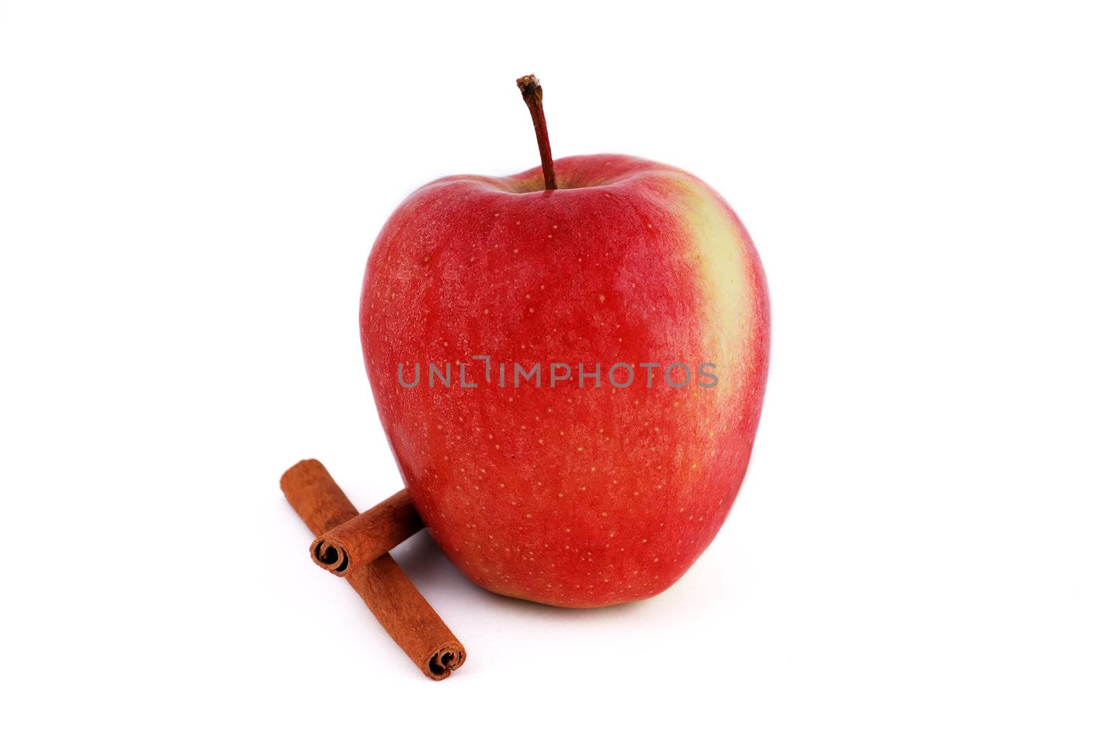 red apple with cinnamon on a white background