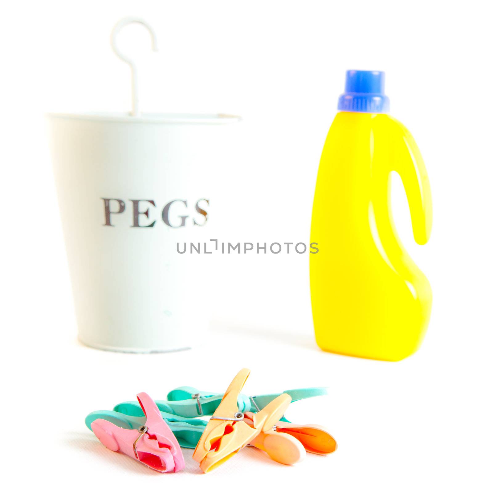 Colorful plastic clothes pegs on a white background