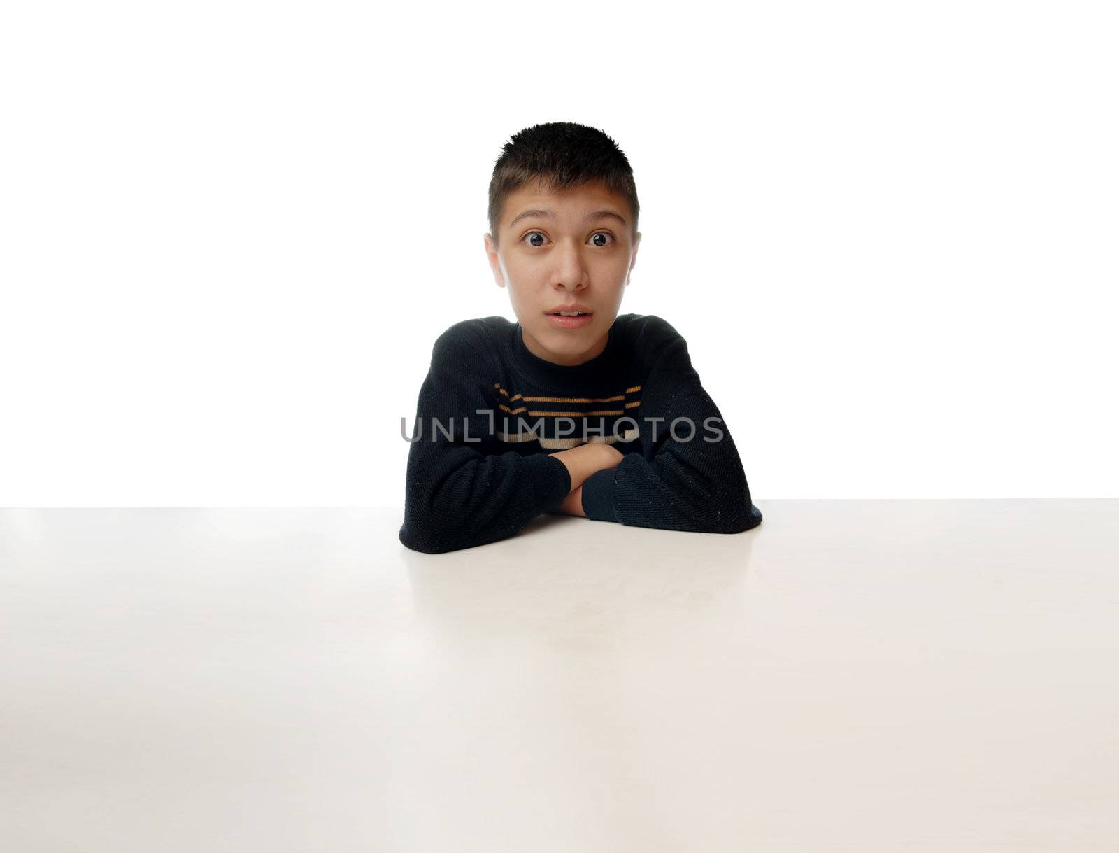 Amazed boy sitting at a huge table as a symbol of human in space