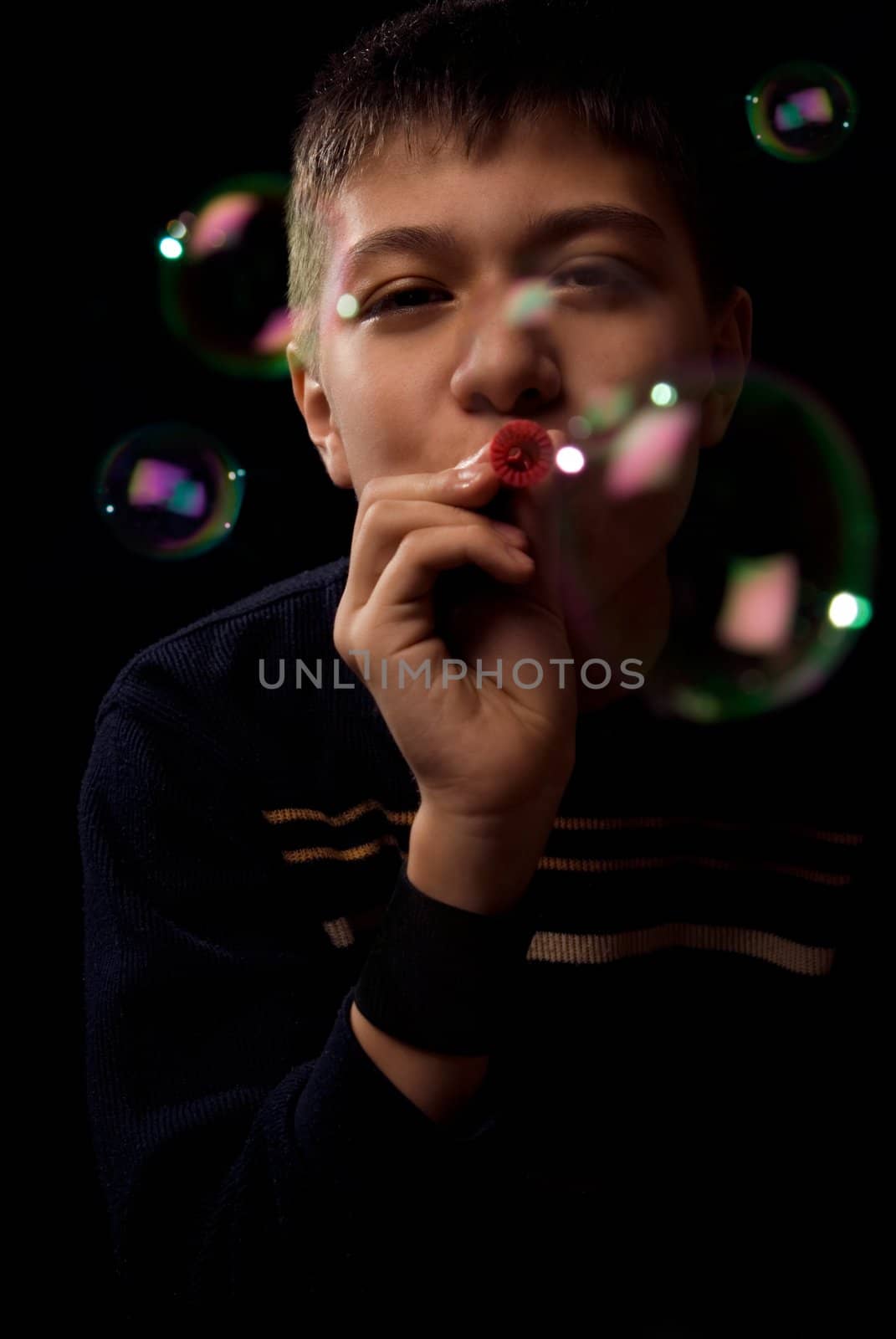 Photo of the young boy blowing soap bubbles