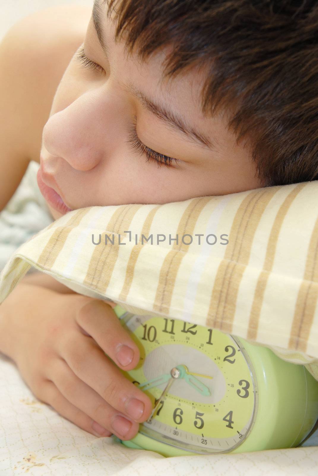 Deep sleeping boy and alarm-clock