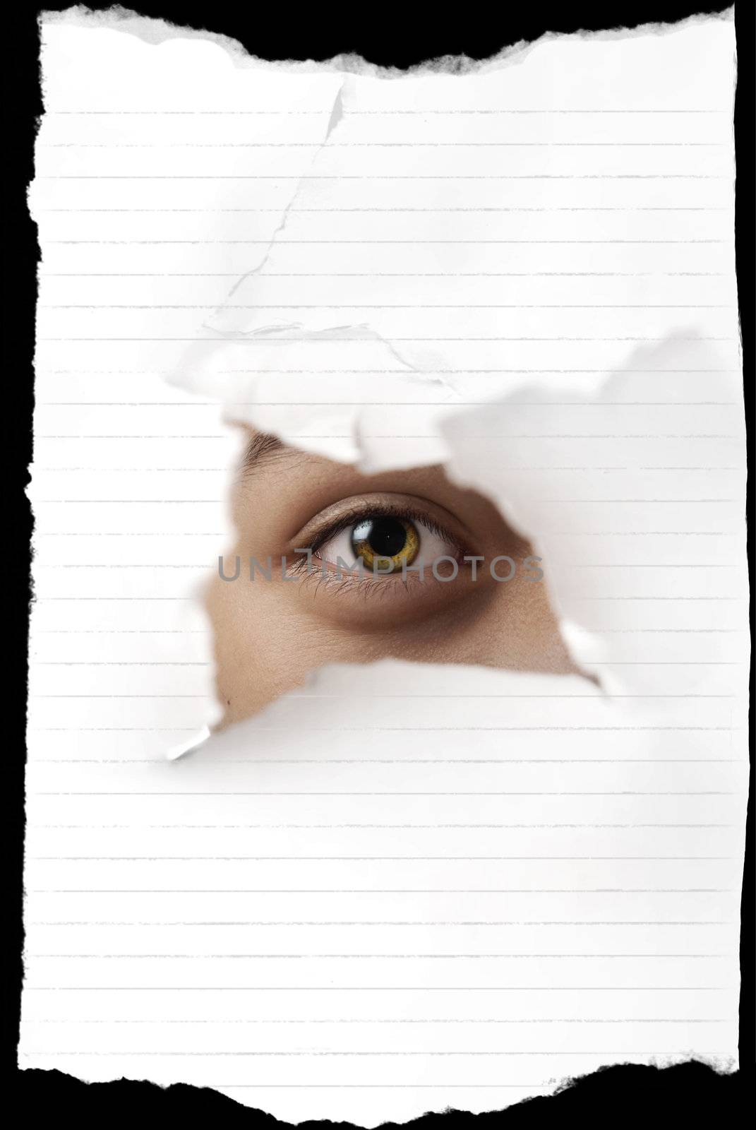 Photo of the green eye looking through the damaged paper