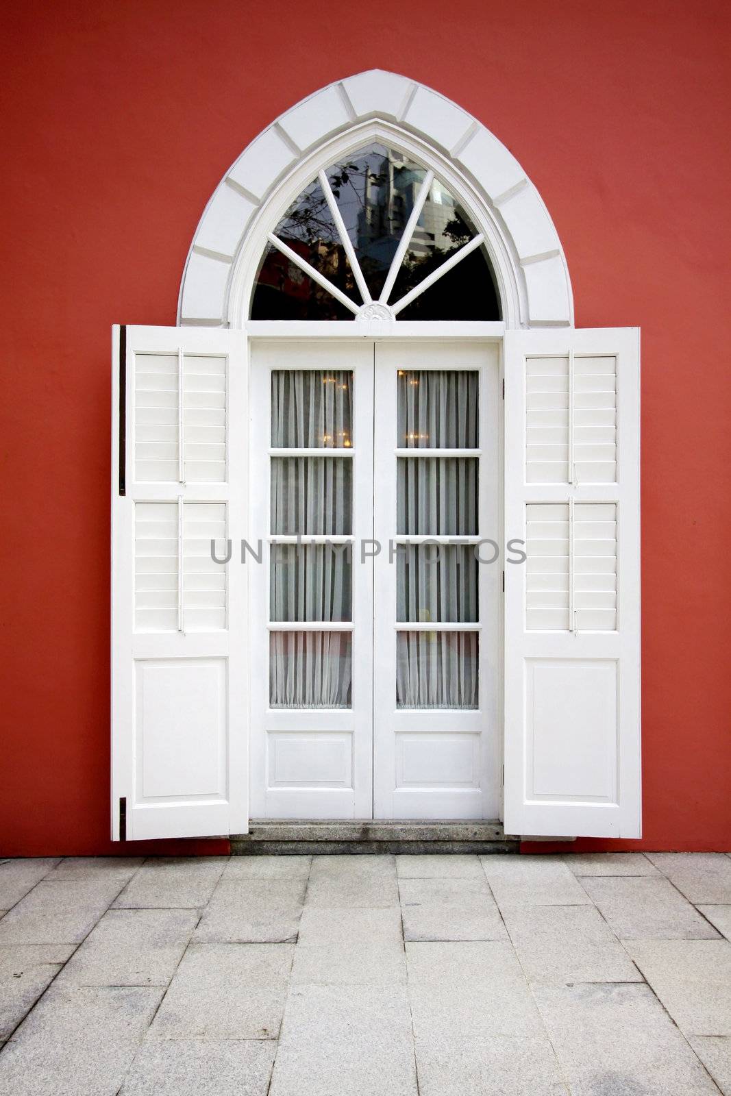 White door on red wall background