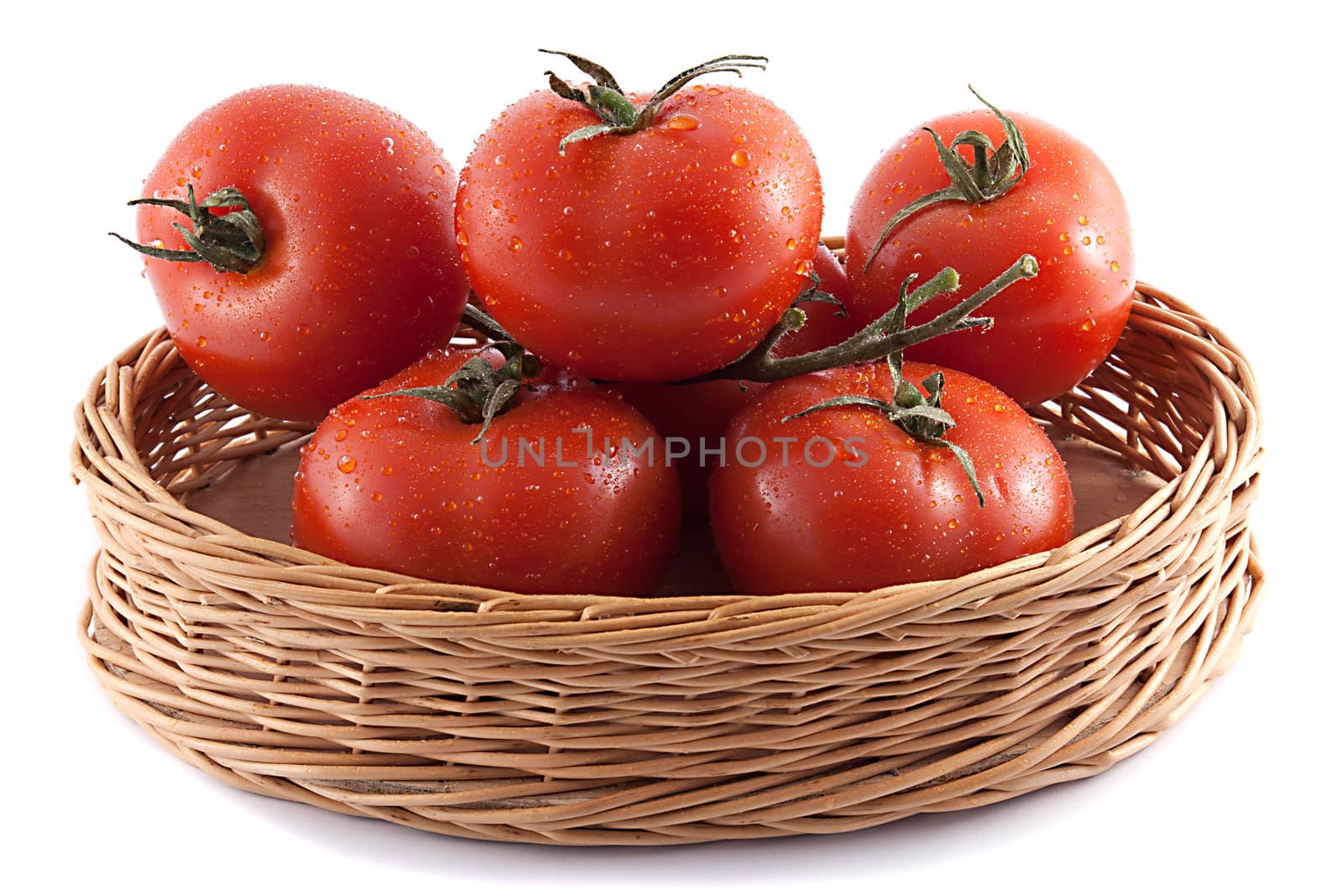 red tomatoes in a wicker basket on white background