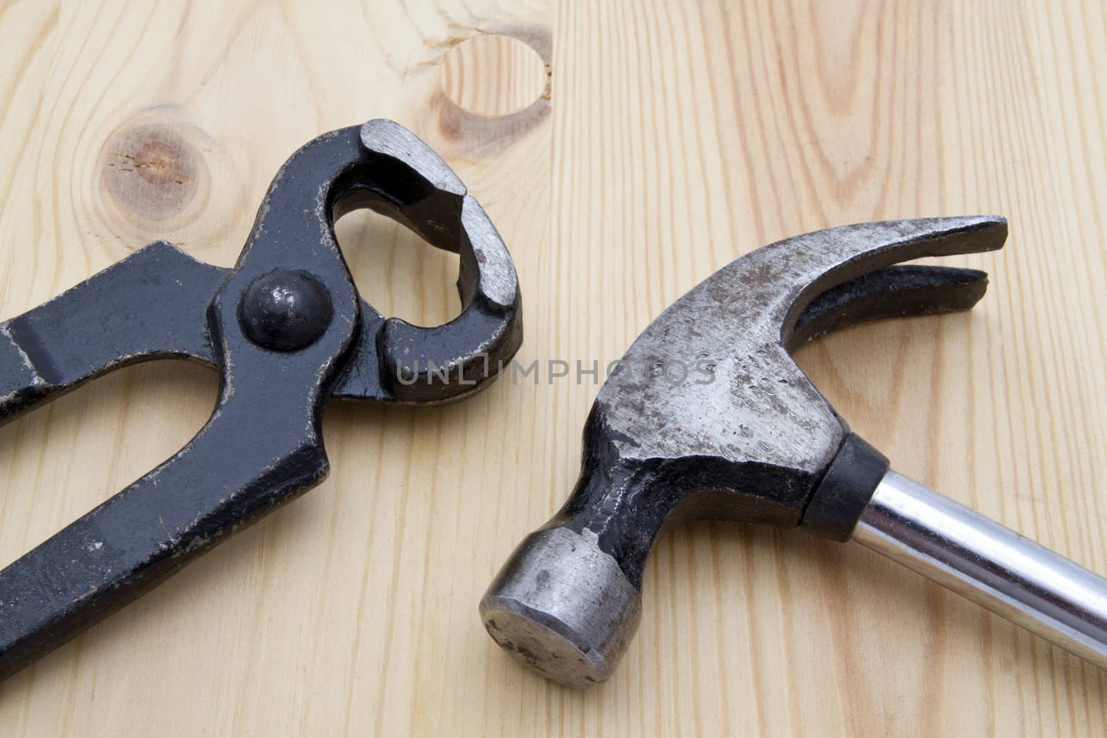 Old wrench and hammer closeup on wood background 
