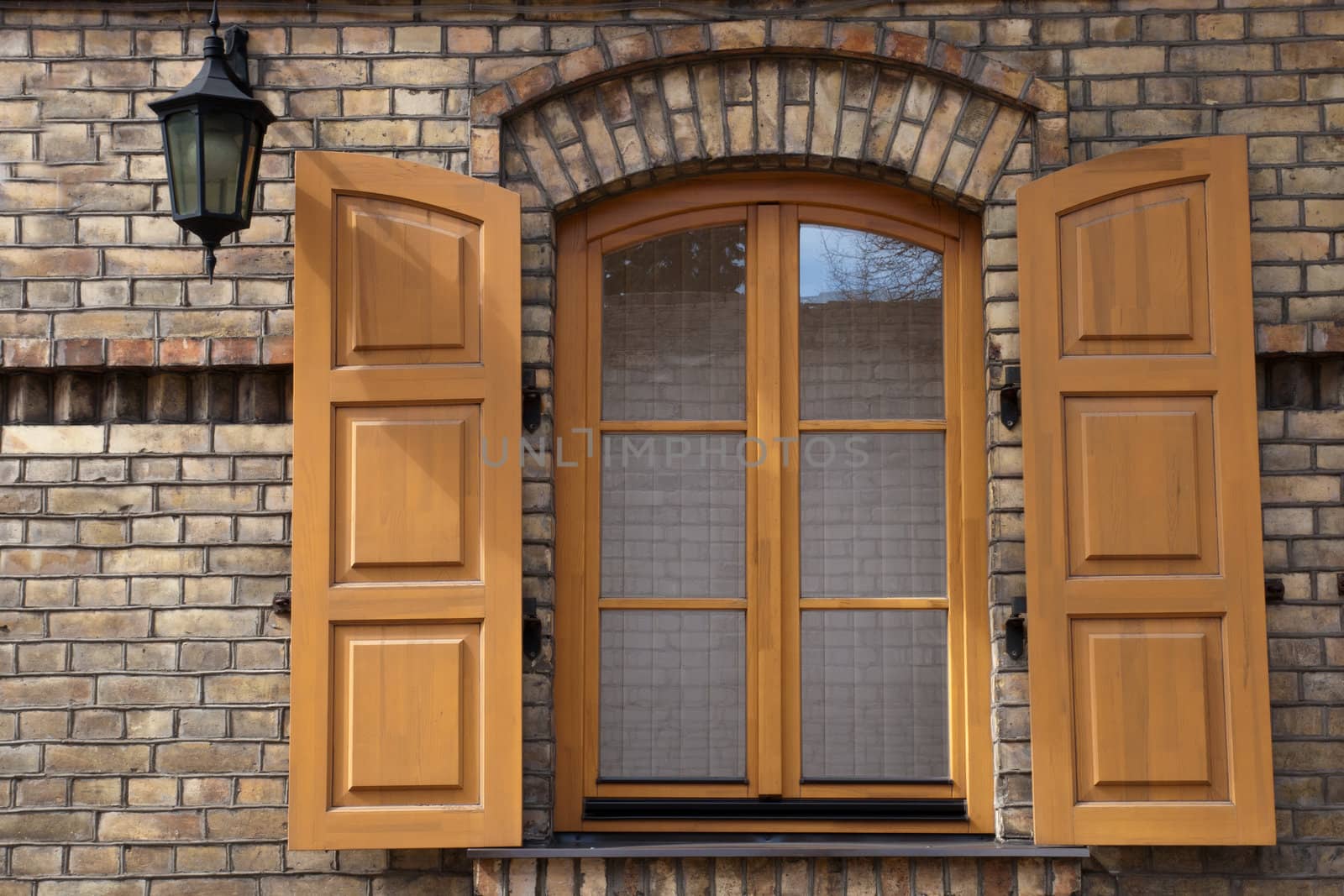window in a brick wall with wooden shutters