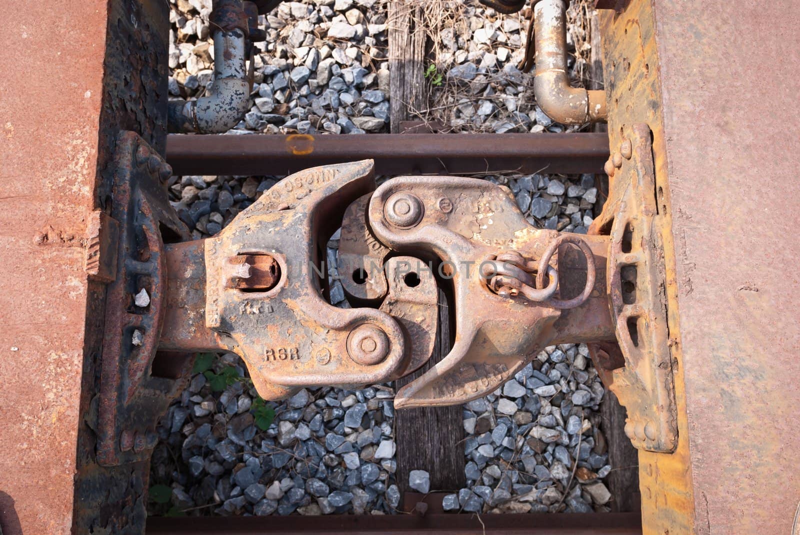 Old and rusty train cabins connector taken from top view on sunny day
