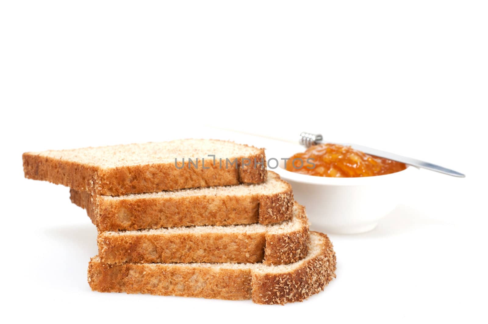 Several slices of whole grain bread with spread photographed on a white background.